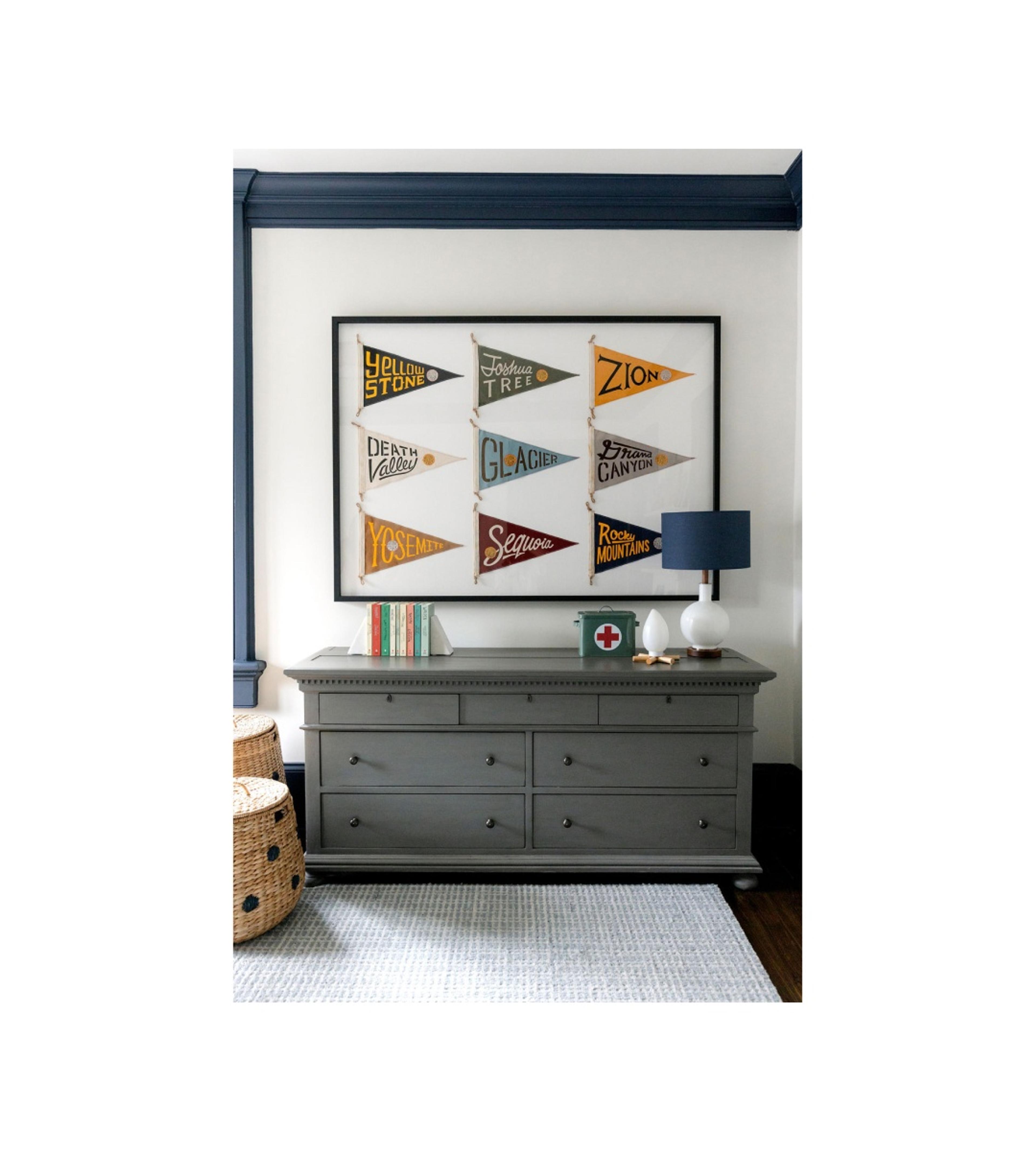 Dresser with pennants framed above it.