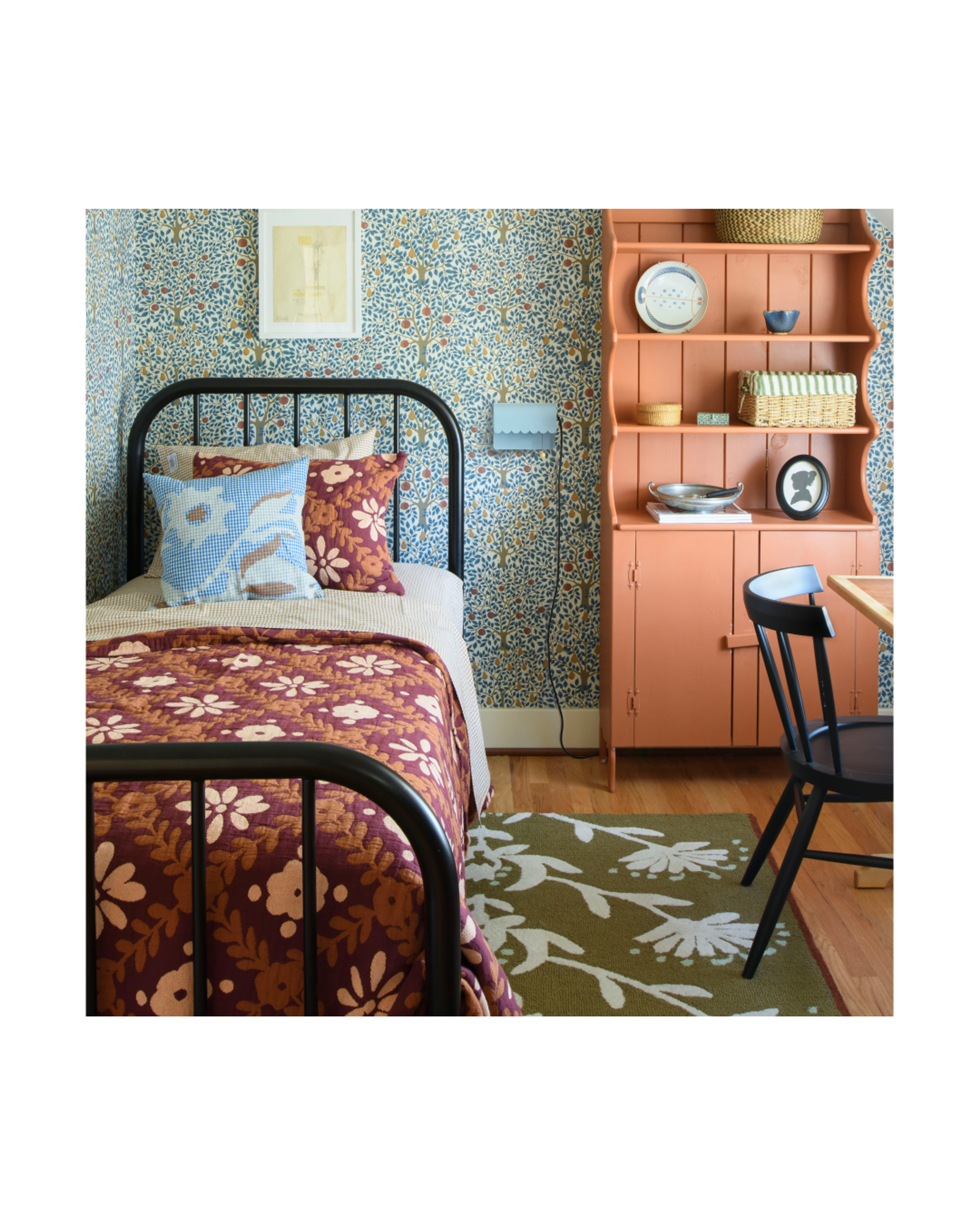 Child's room with blue and green wallpaper and pink shelf.