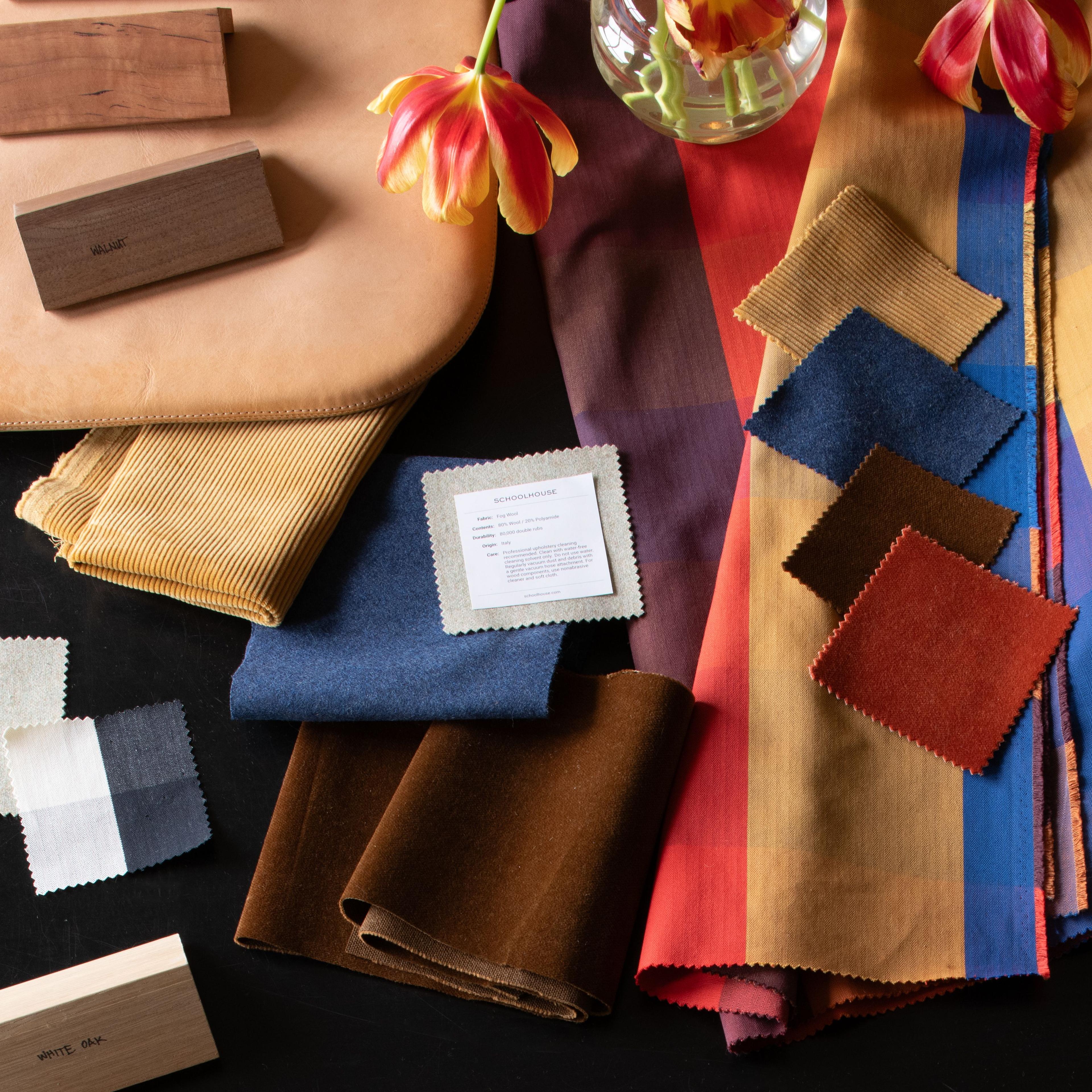 Hands holding upholstery samples over textiles. 