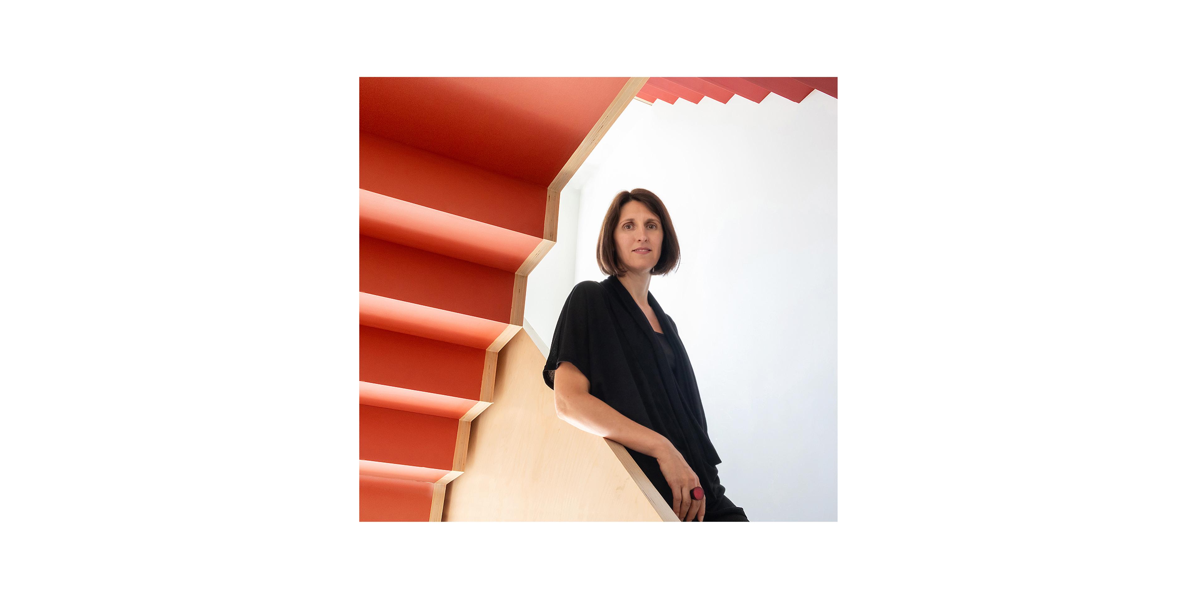 Woman standing on a red staircase.