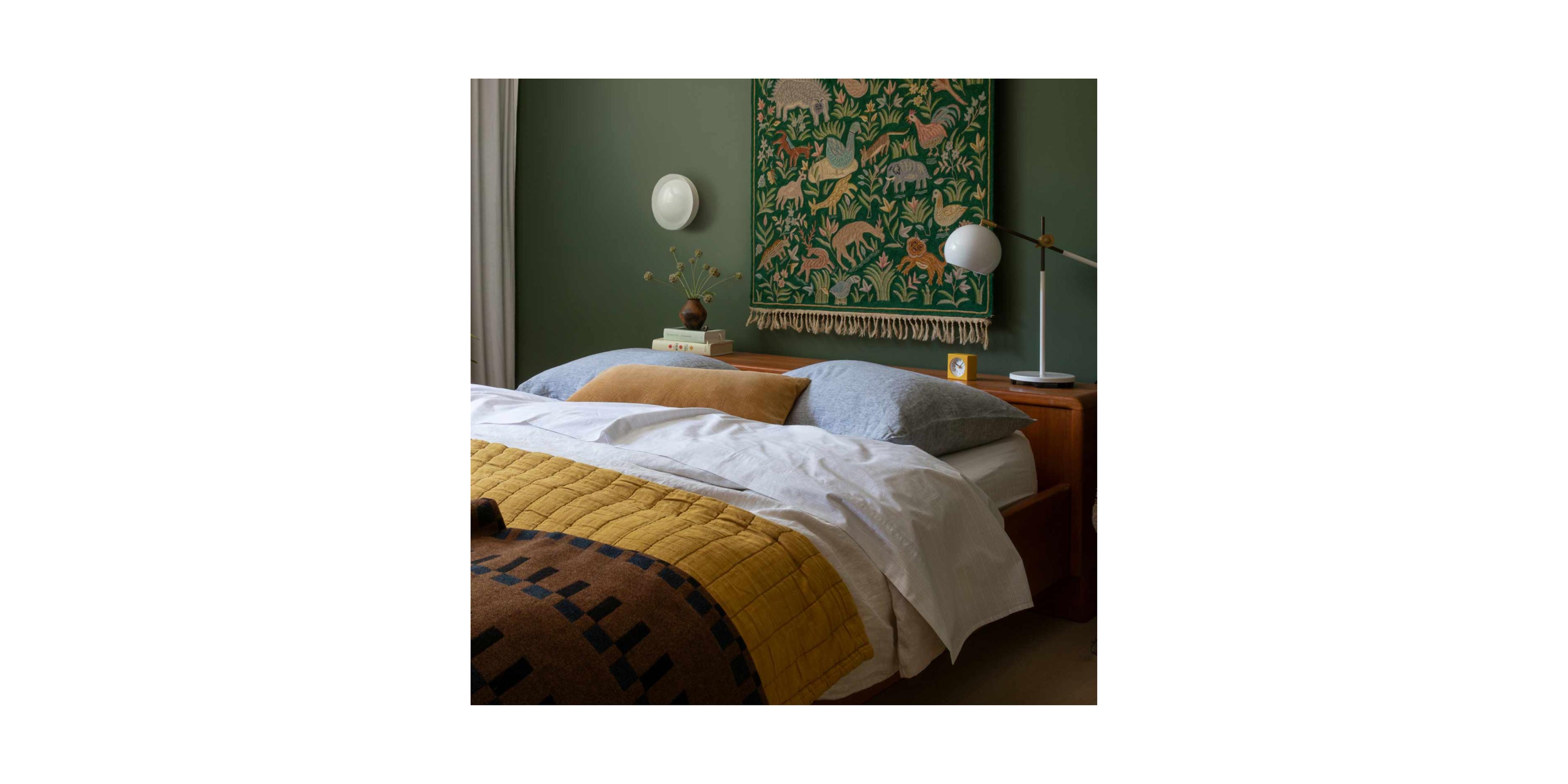 made bed with mustard quilt and animal print tapestry on the wall above wood headboard