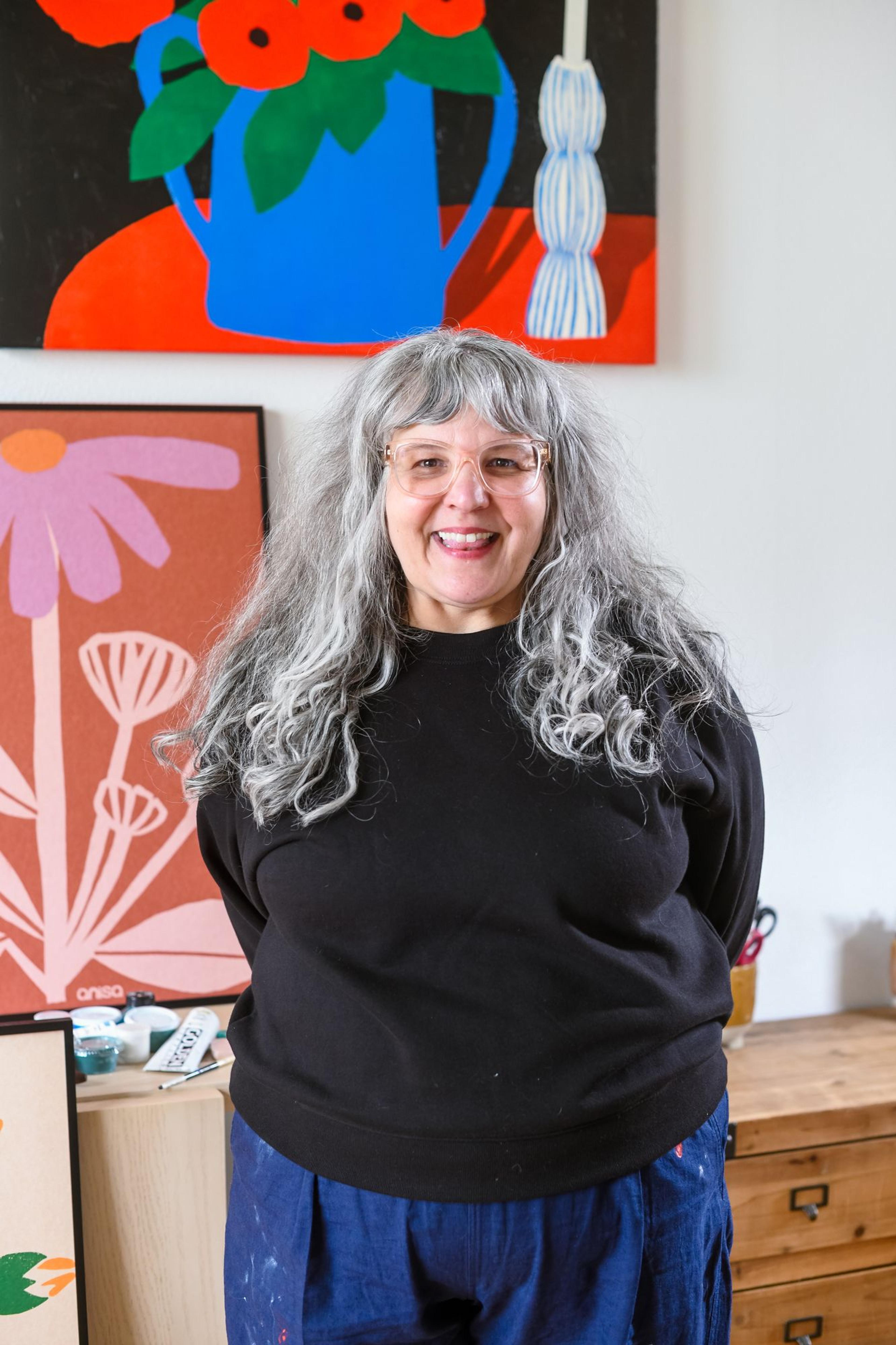 portrait of artist anisa makhoul smiling cheerfully in her studio