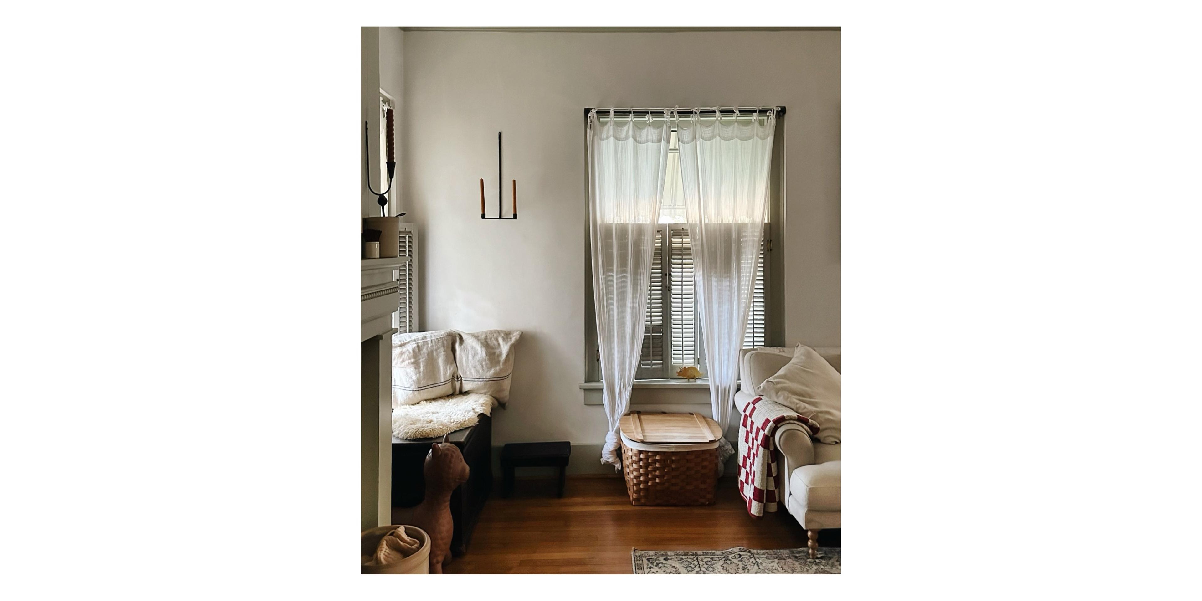 Livingroom window with wooden shutters and woven basket underneath