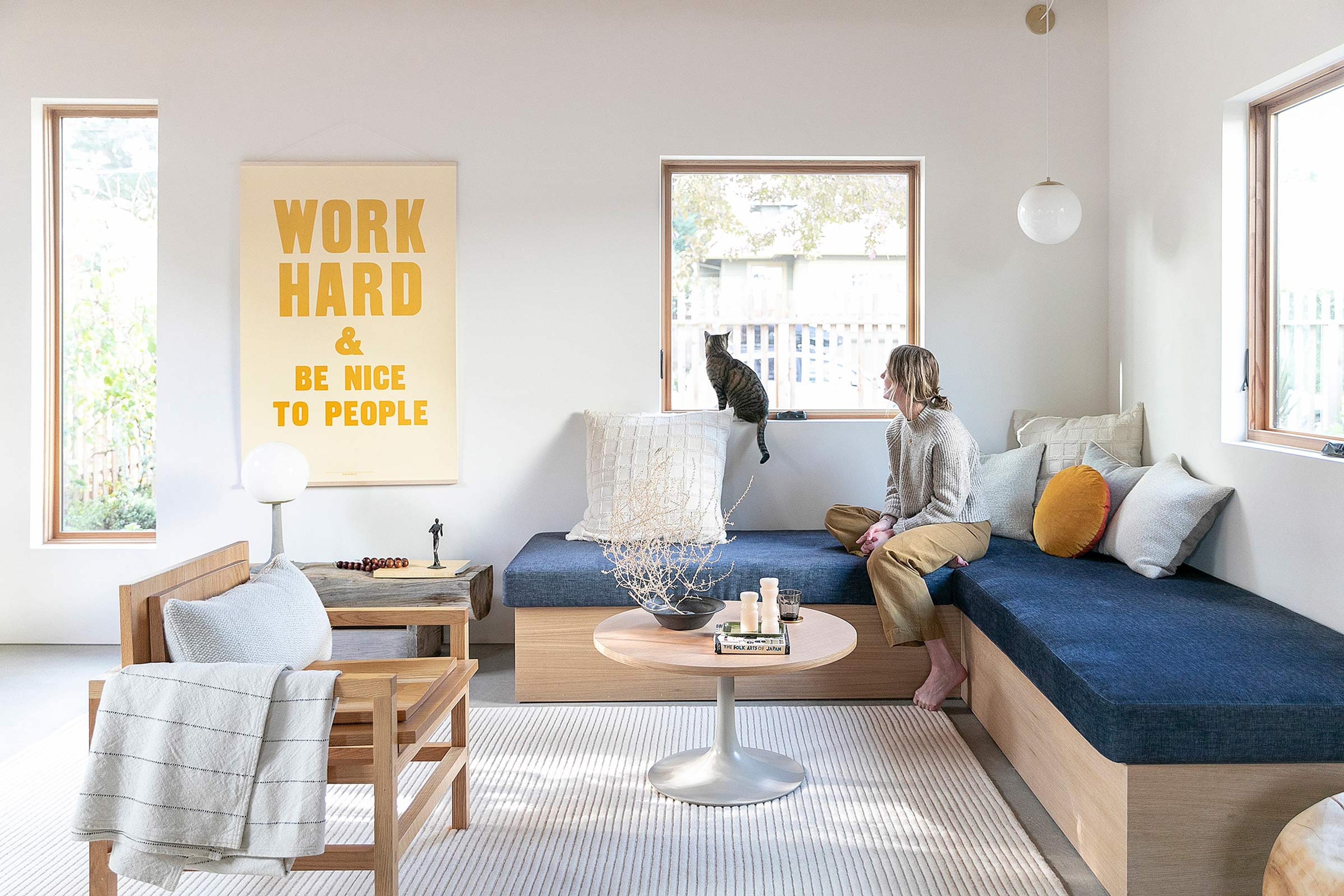 Scandinavian-inspired living room with a built-in blue bench and pendant light.