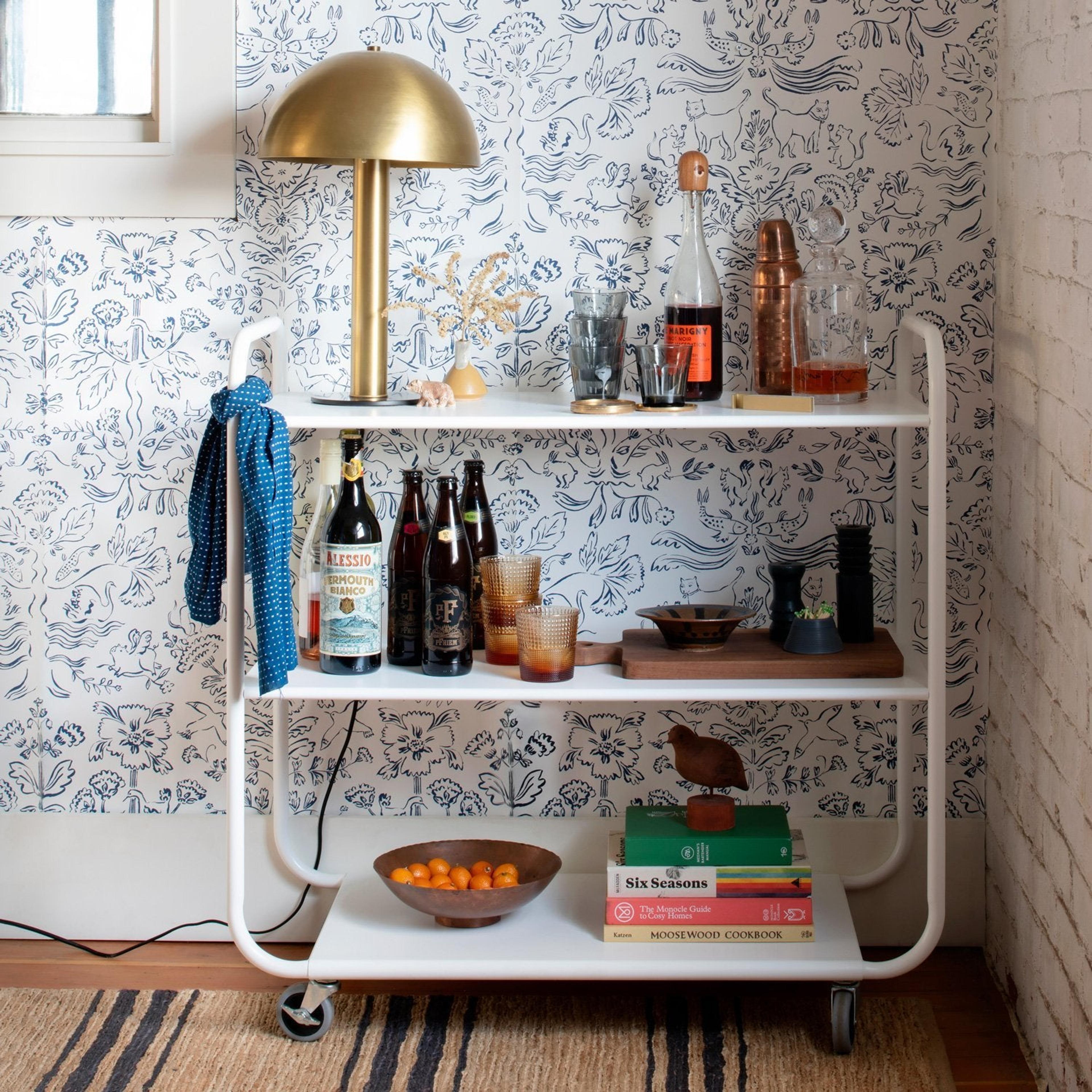 Bar cart with white mushroom shaped lamp and alcohol bottles