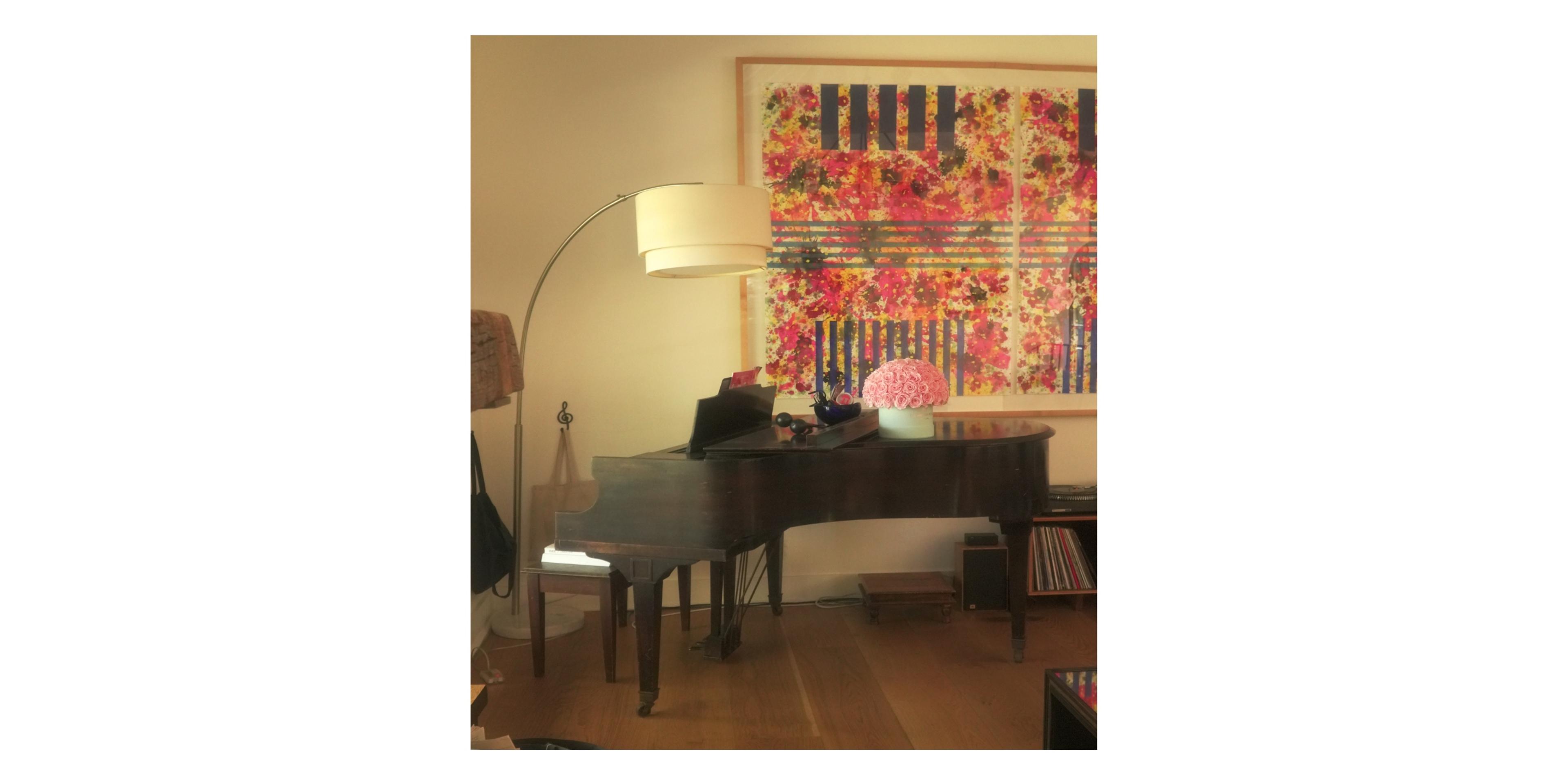 piano in corner of room with lamp over hanging 