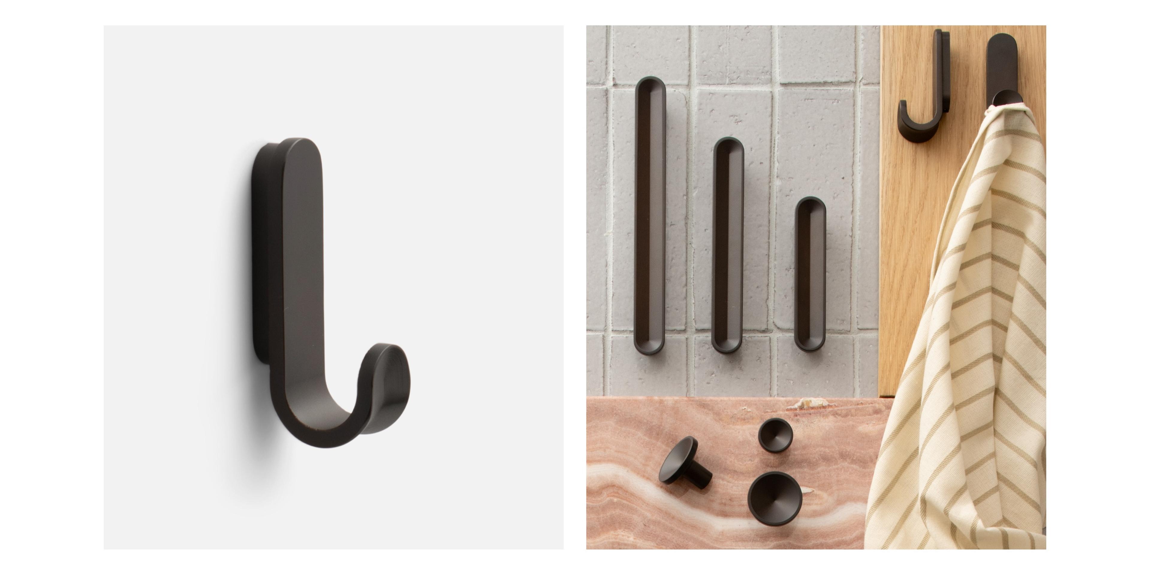 Black pulls, hook and knobs on white background and tiled surface