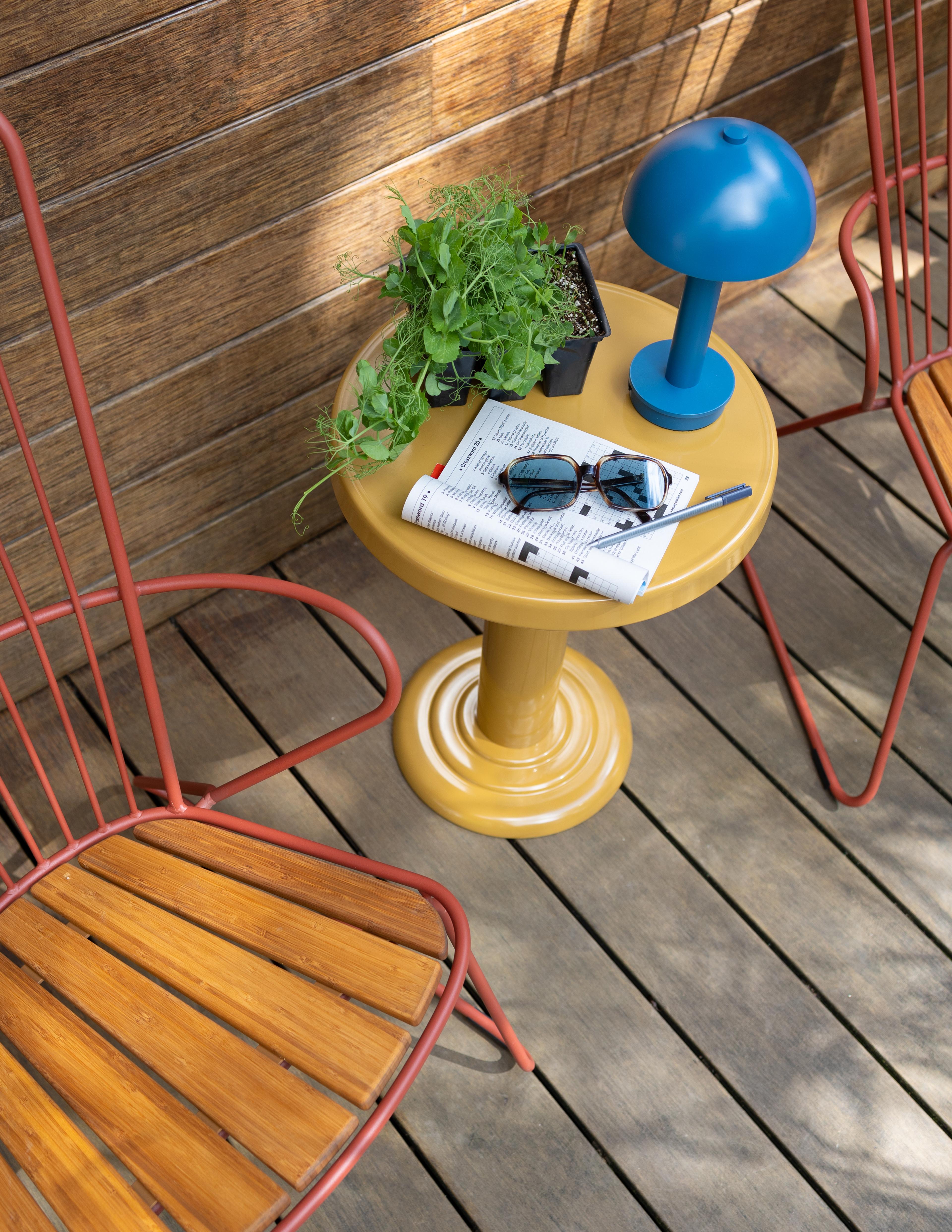 Small blue portable lamp on dune outdoor side table