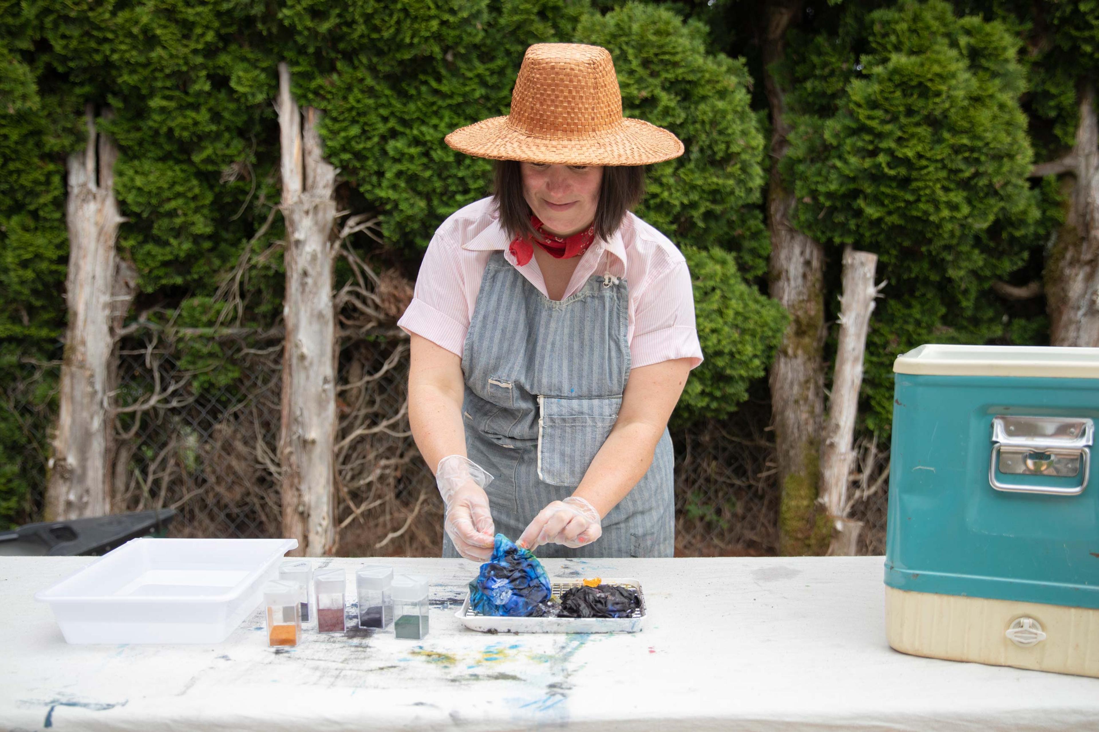 Woman ice-dyeing fabric in her backyard.