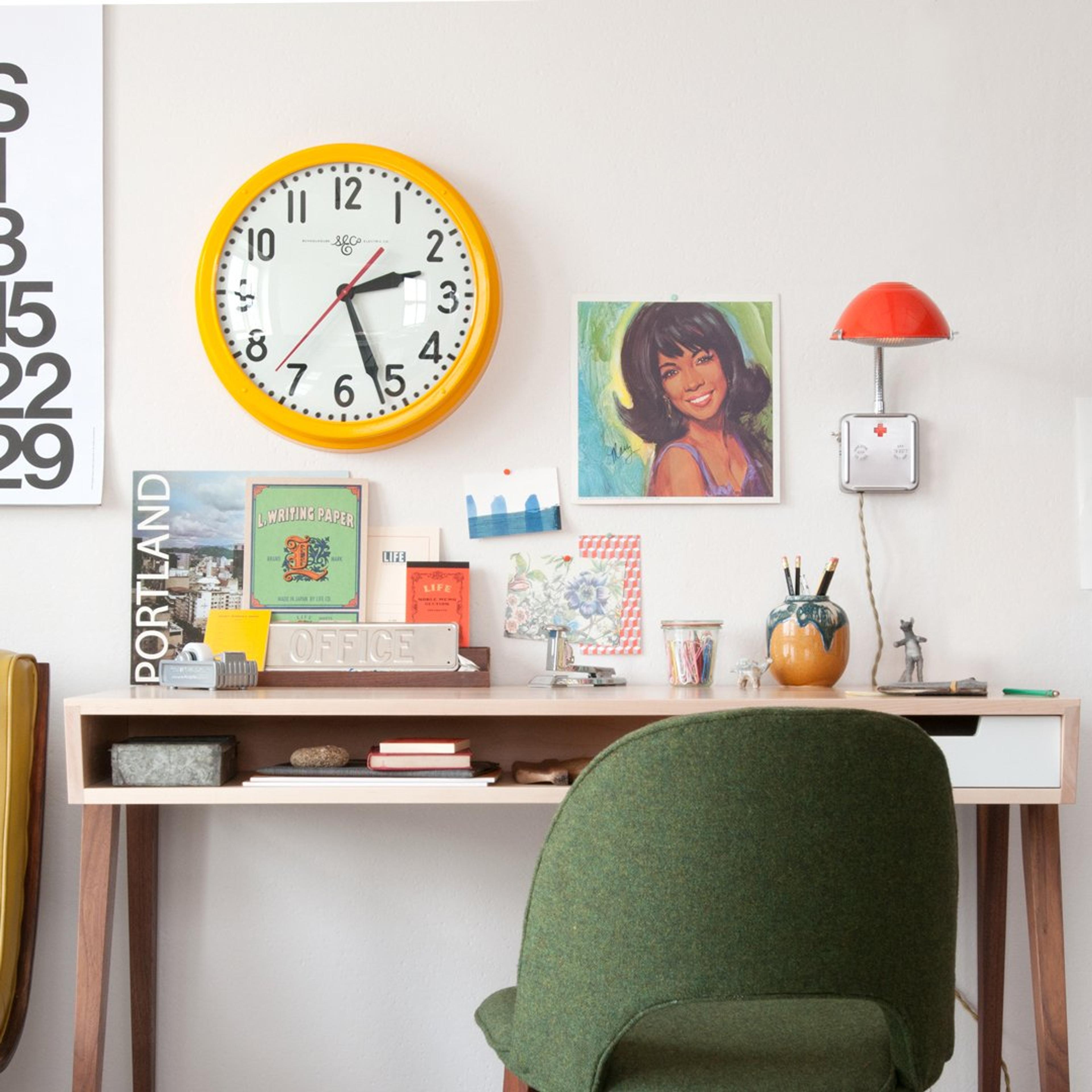 desk with yellow clock overhead and vintage desk accents