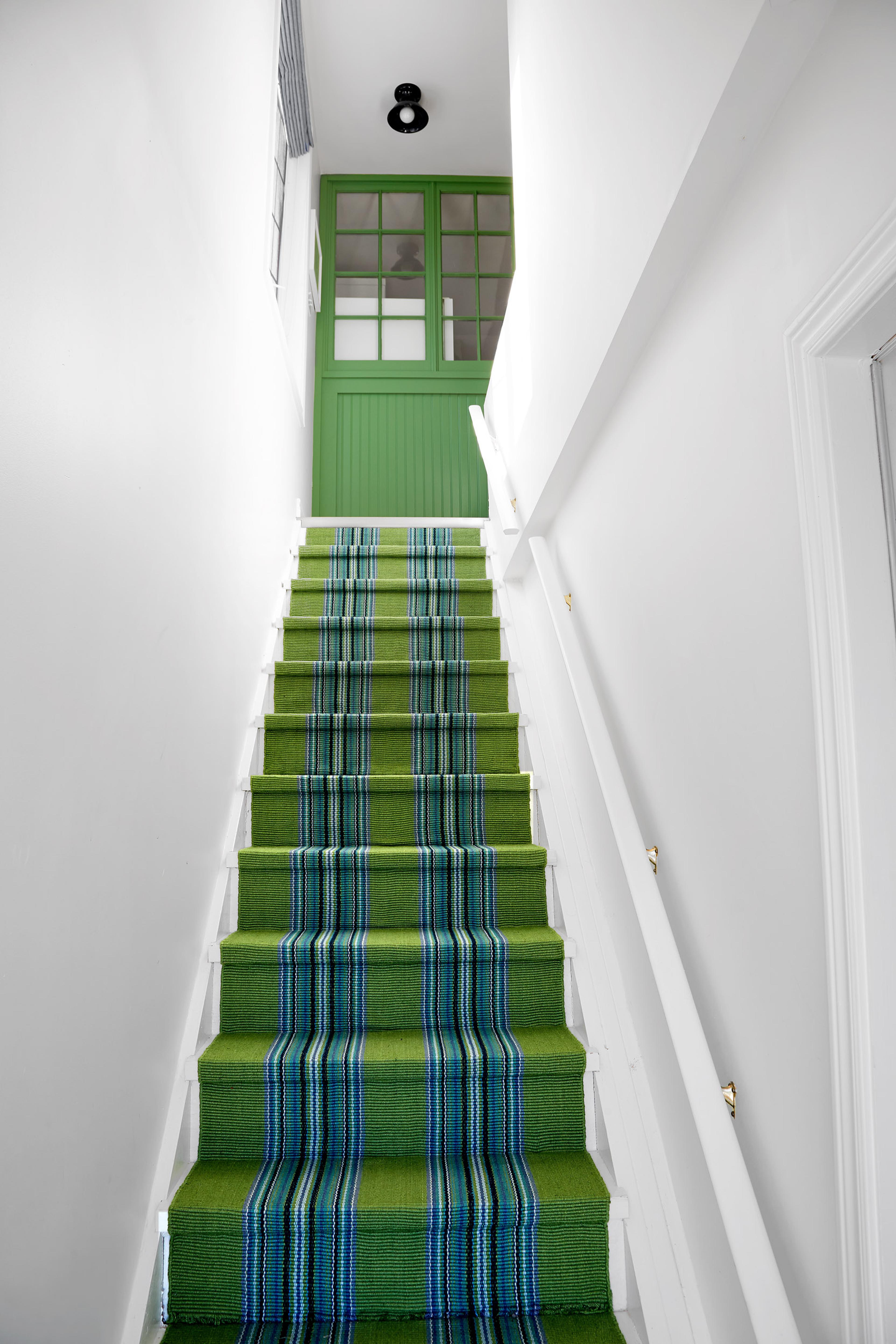 staircase with an emerald rug