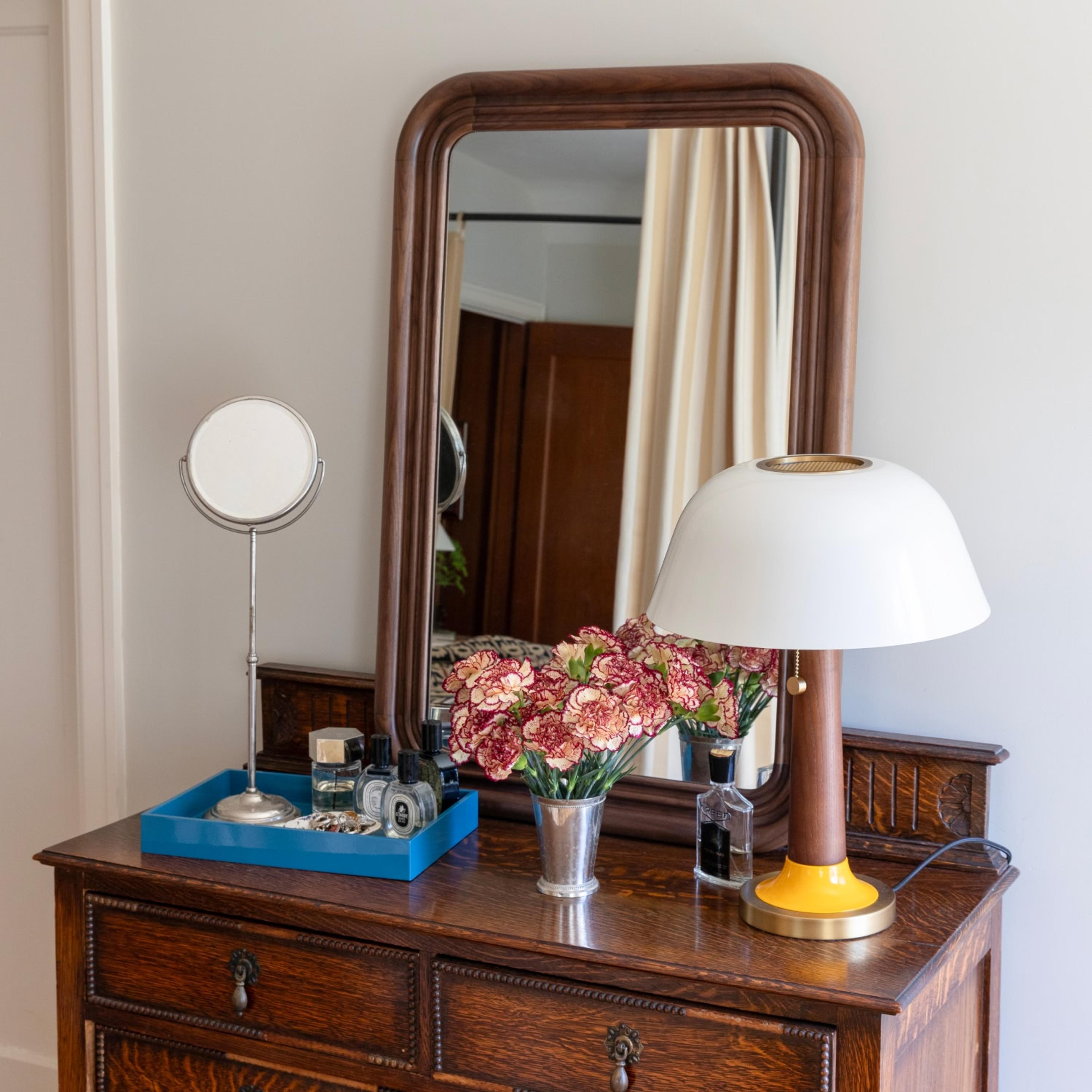 Walnut mirror on vintage dresser with decor 