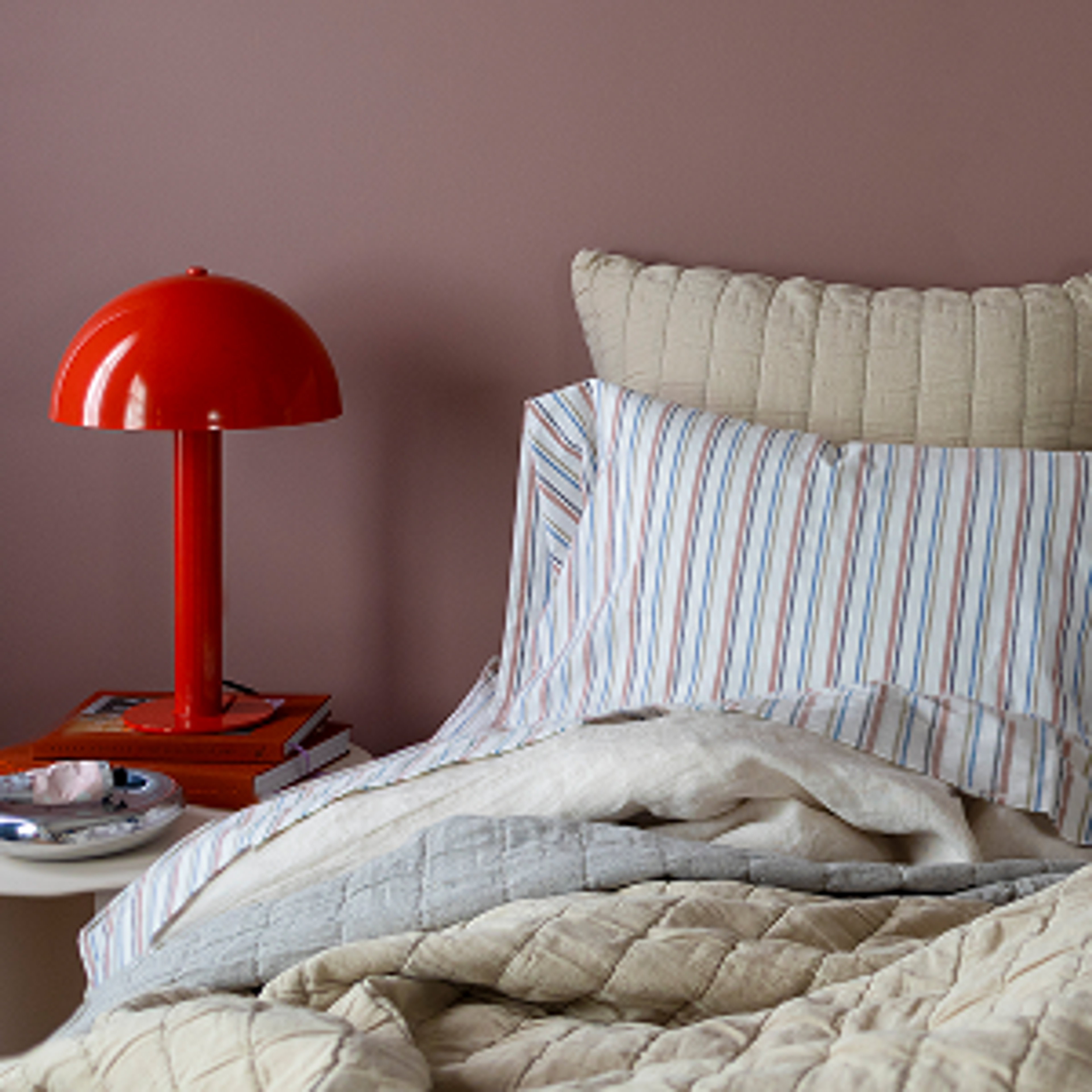 Cozy bed with table lamp on nightstand