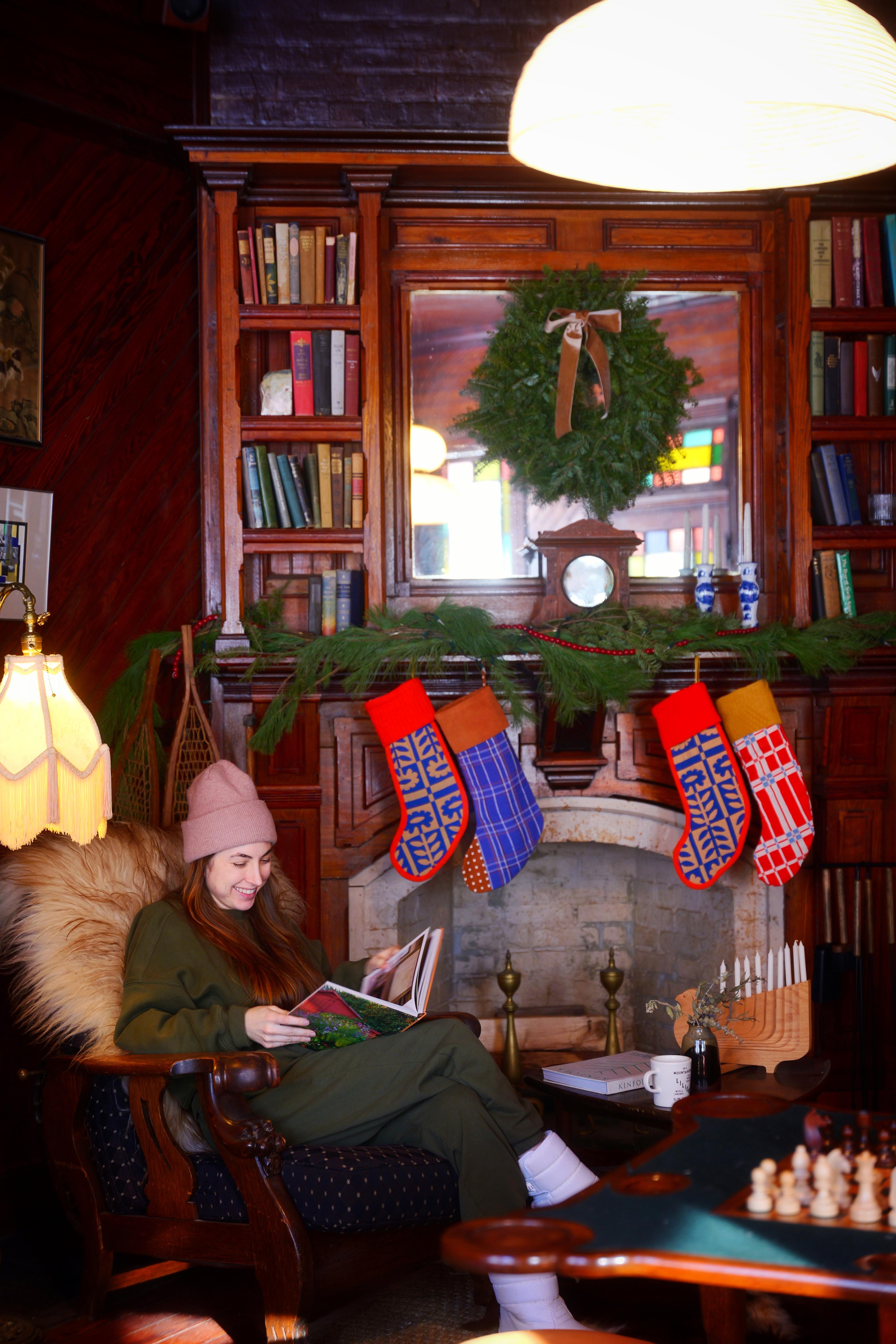 Woman sitting by fireplace.