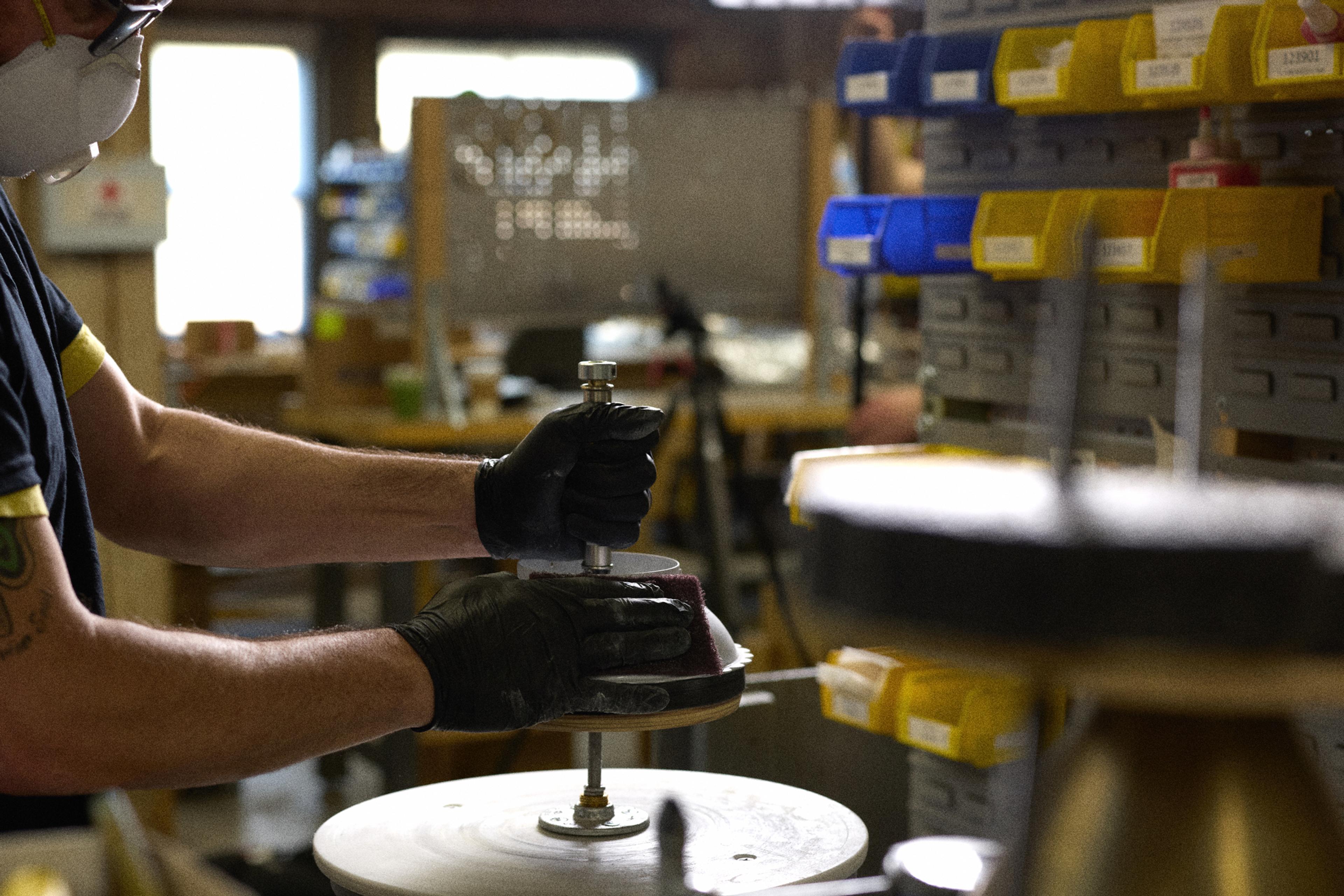 person sanding light fixture for painting