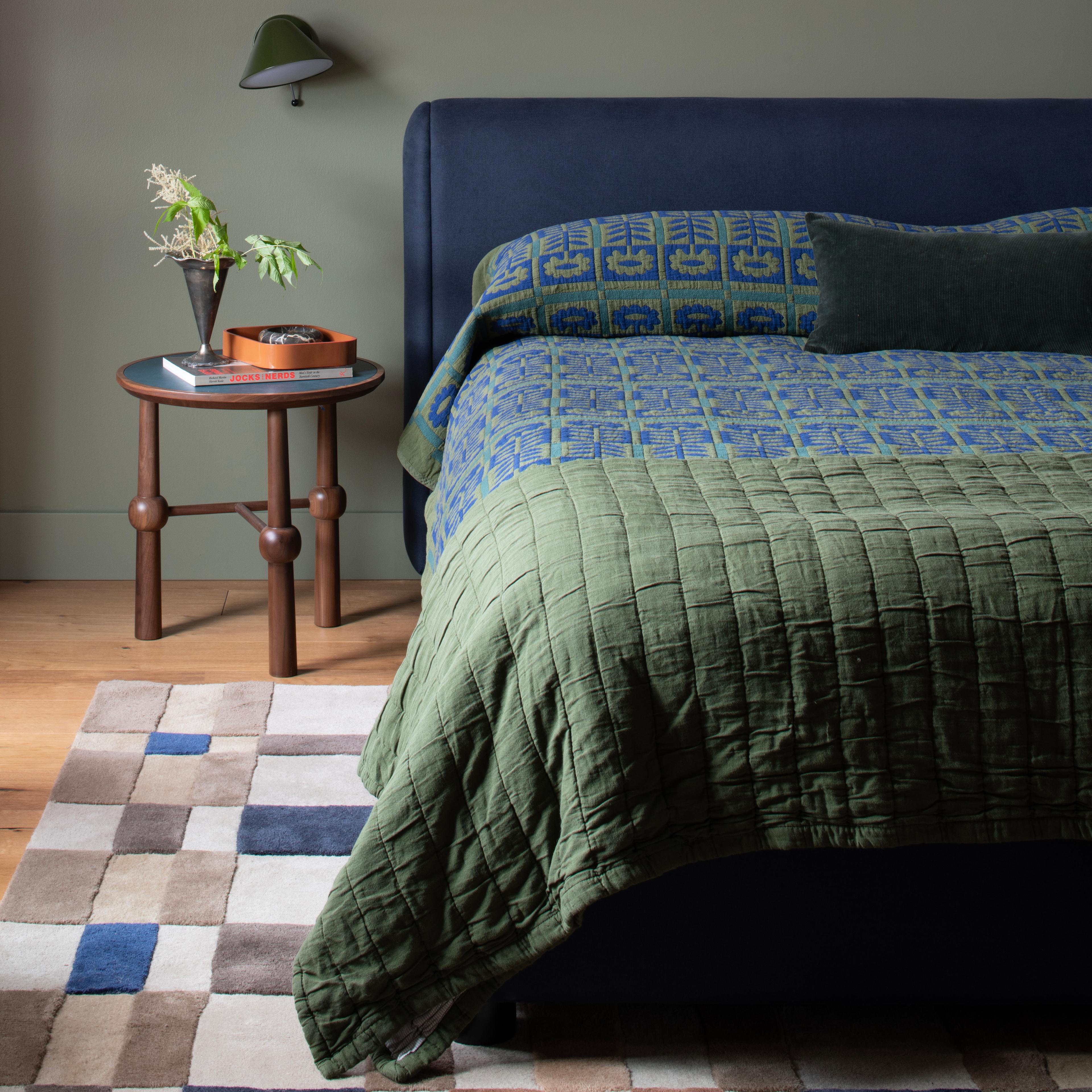 Moody bed with dark blue and forest green hues.