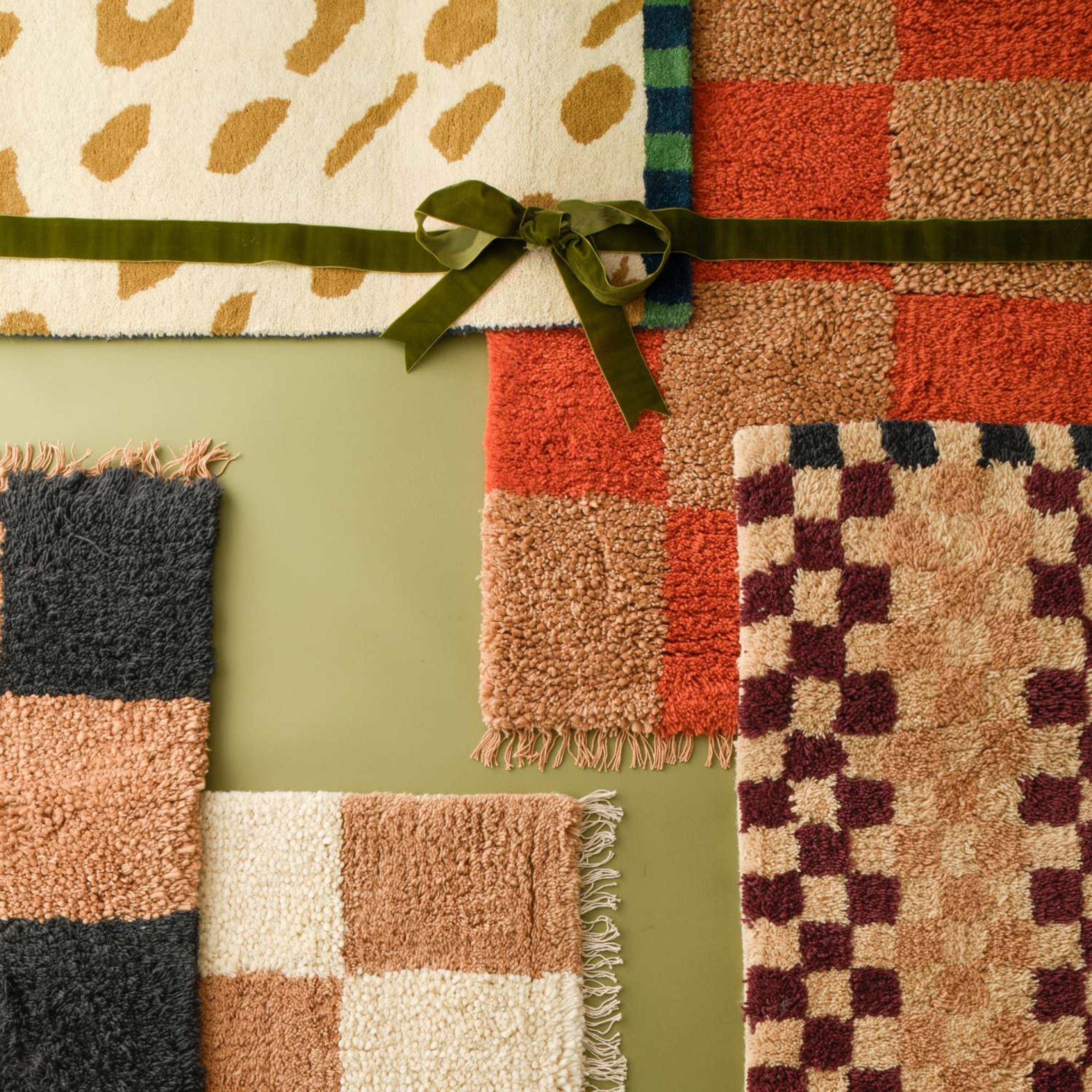 Schoolhouse x Clare V. rugs layered on each other with a bow