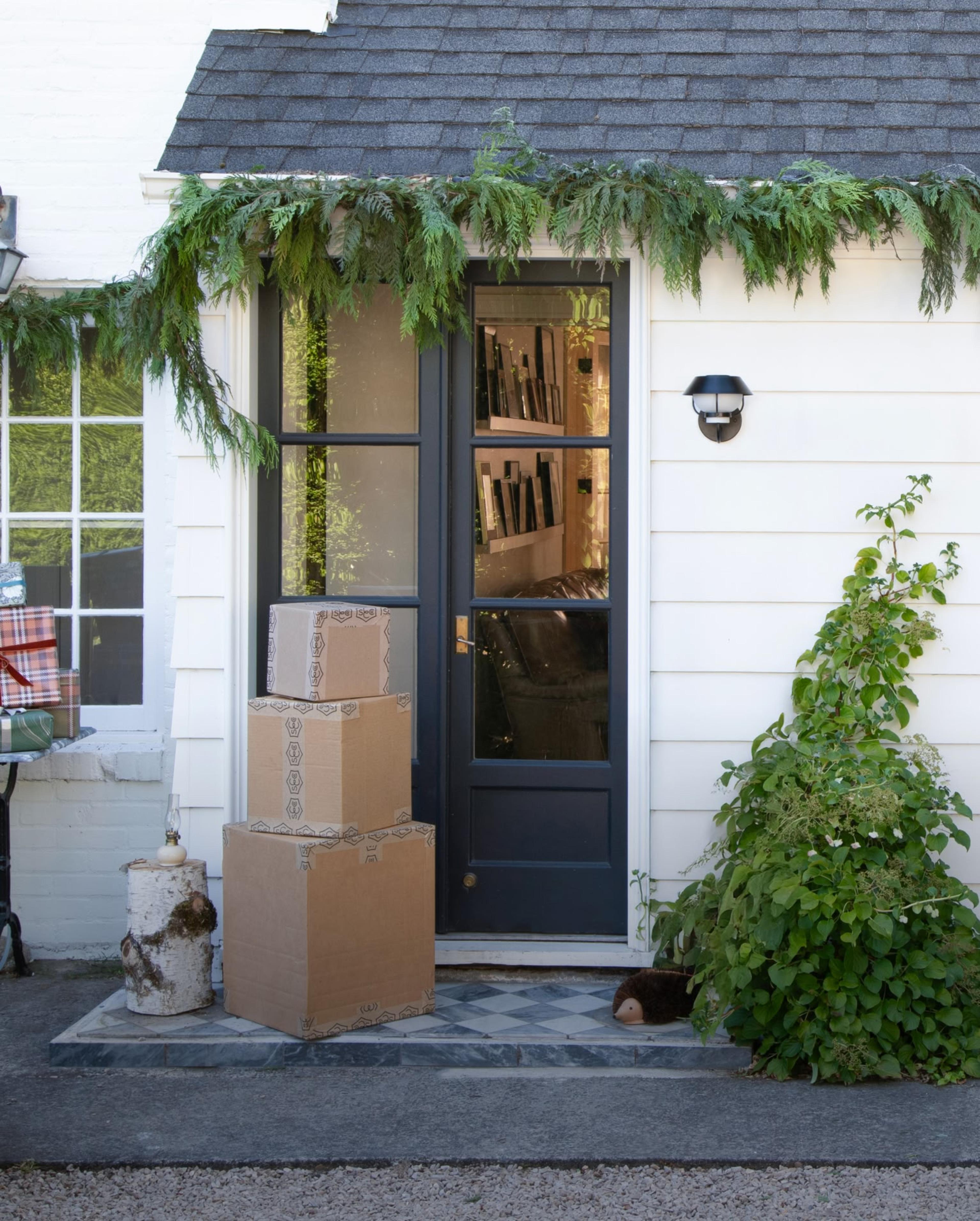 Exterior of white home with stacked shipping boxes