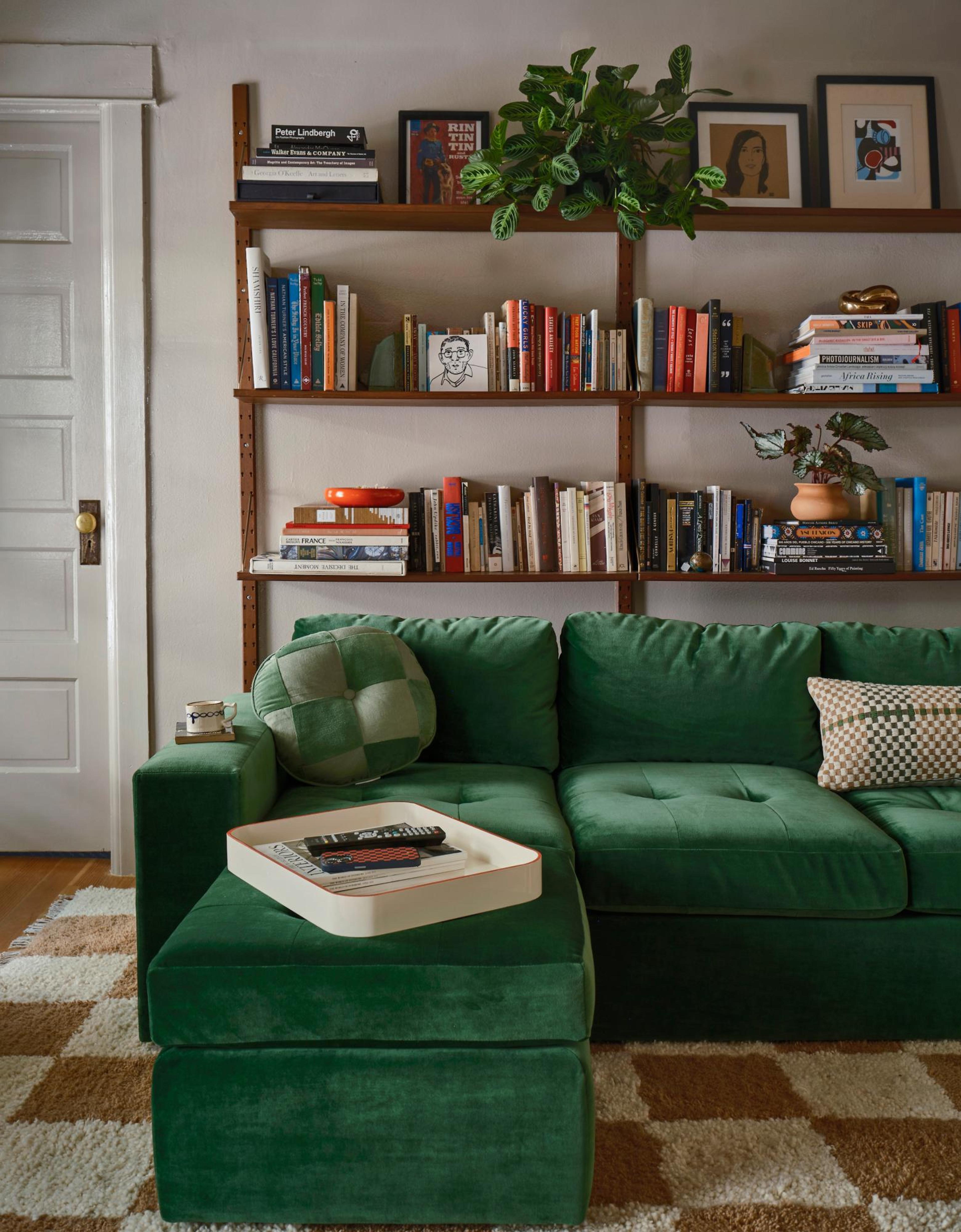 Green couch on white and brown checkered rug 