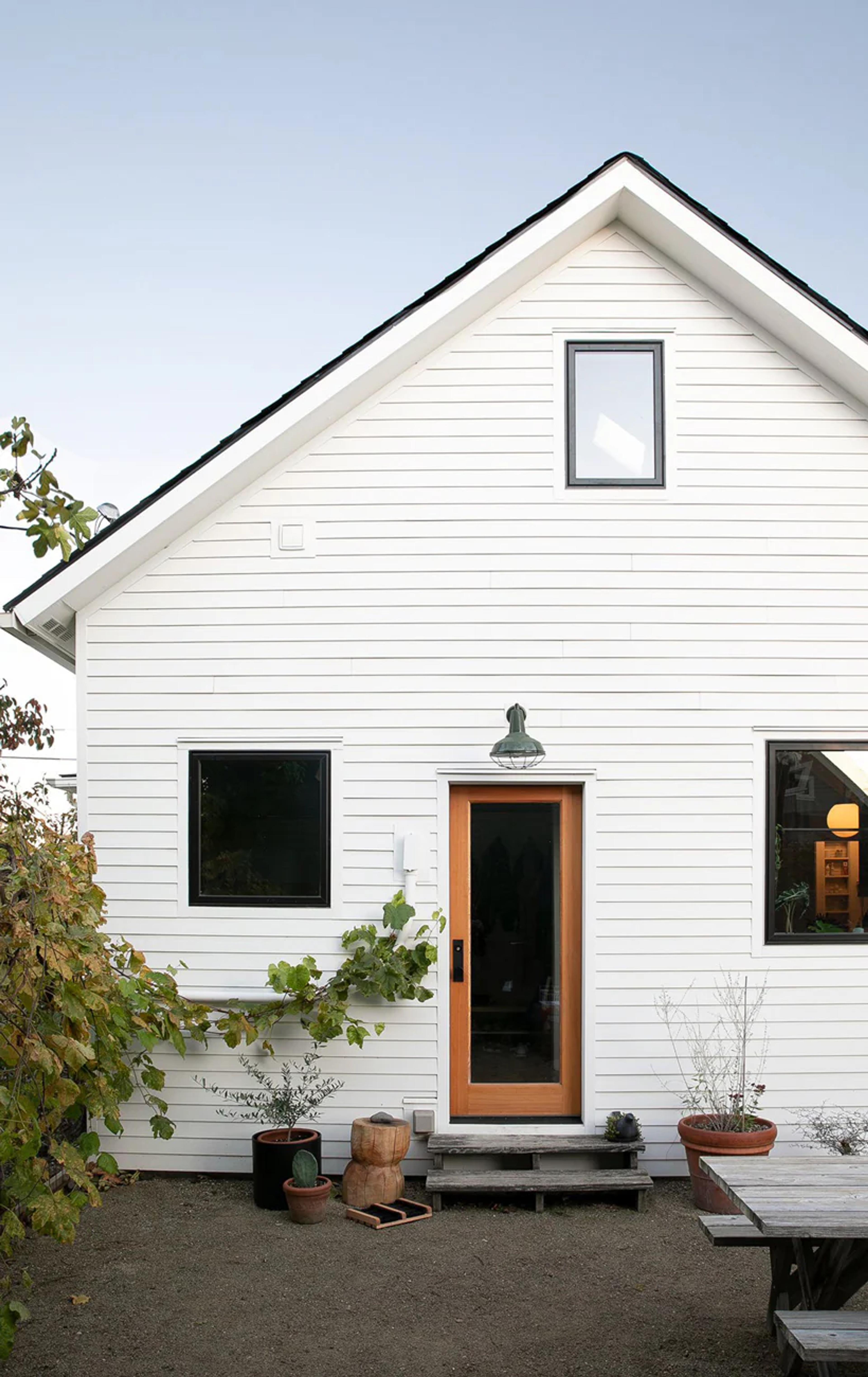 A white farmhouse with a brown door