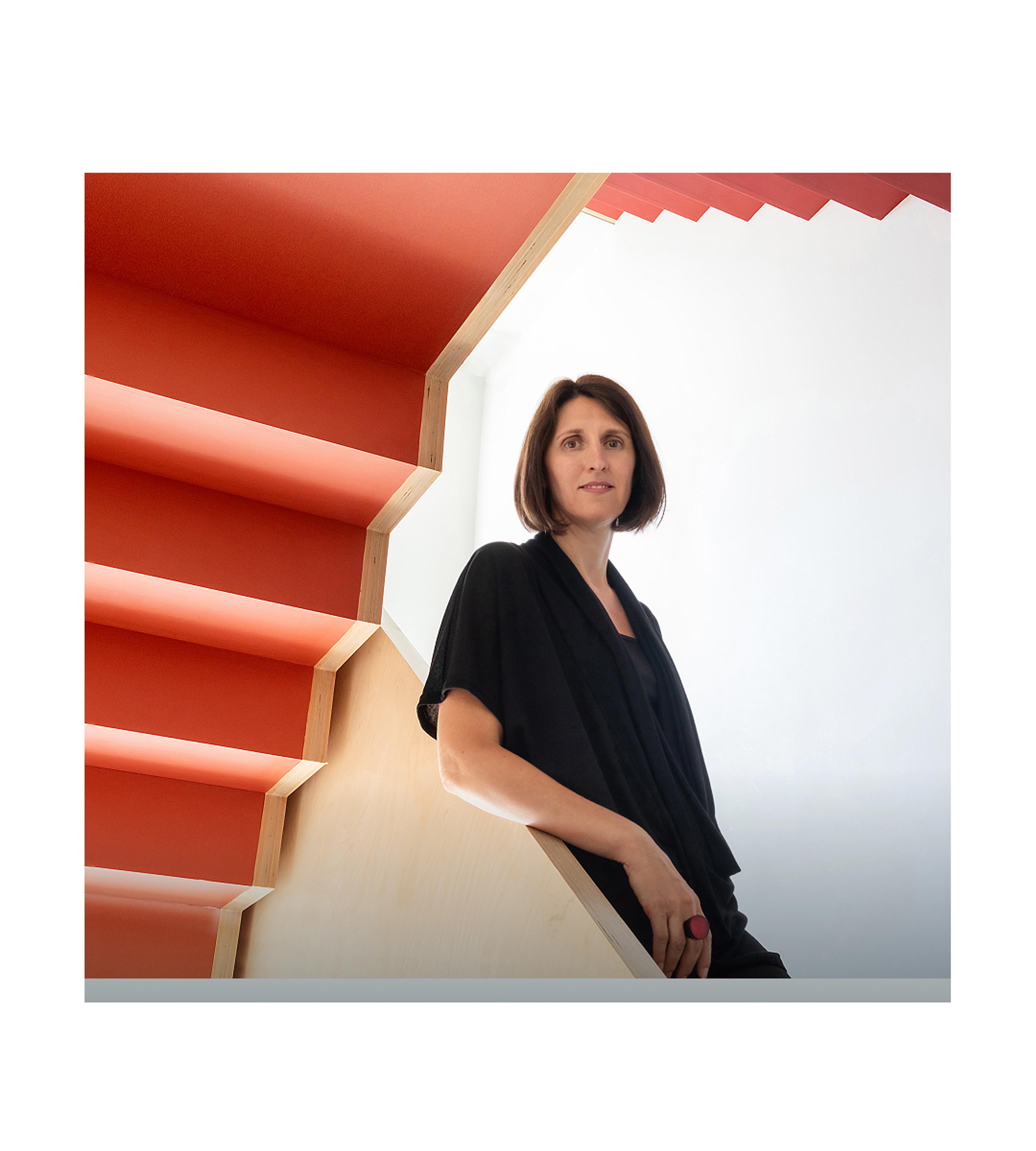 Woman standing on a red staircase.