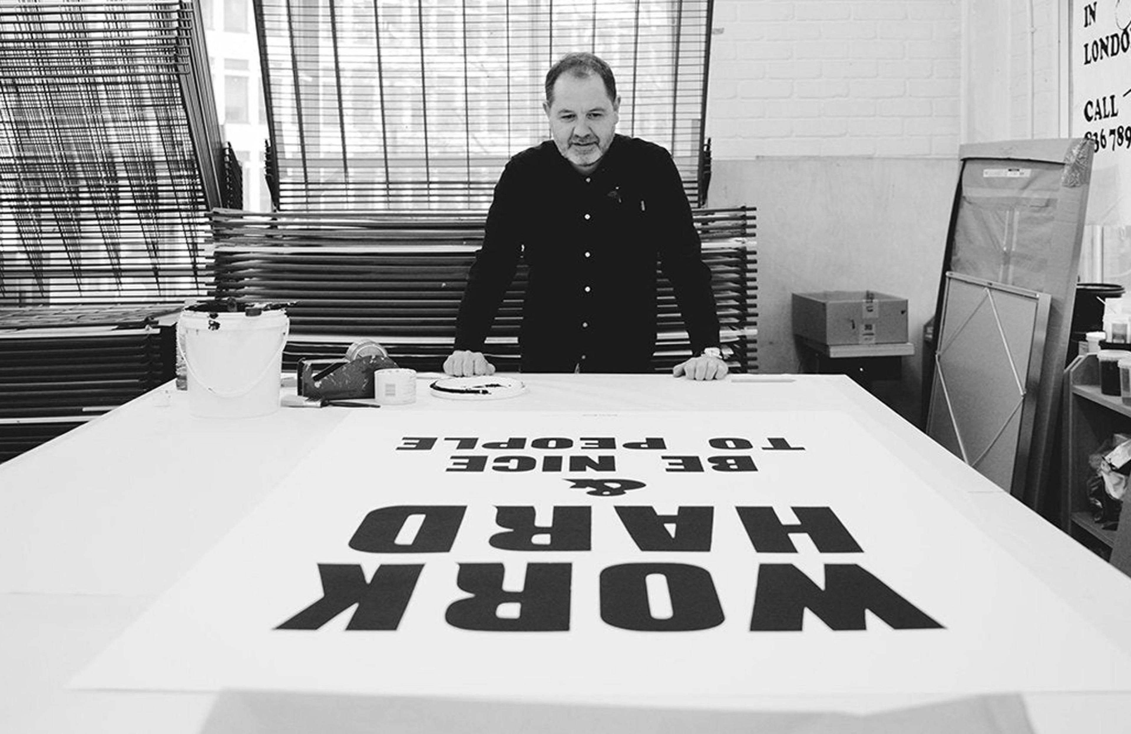 Anthony Burrill looking at his art piece