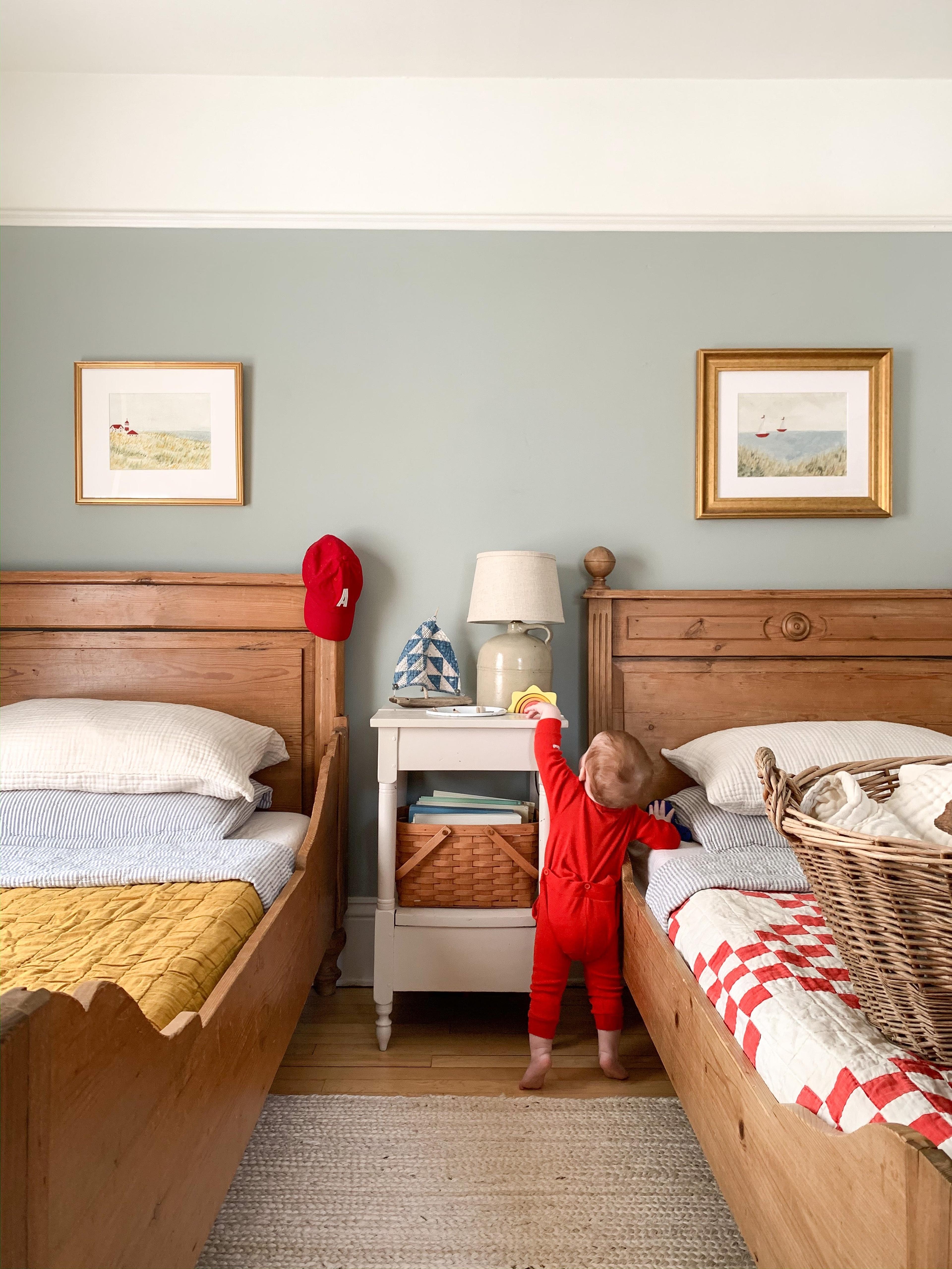 baby in a bedroom with two beds