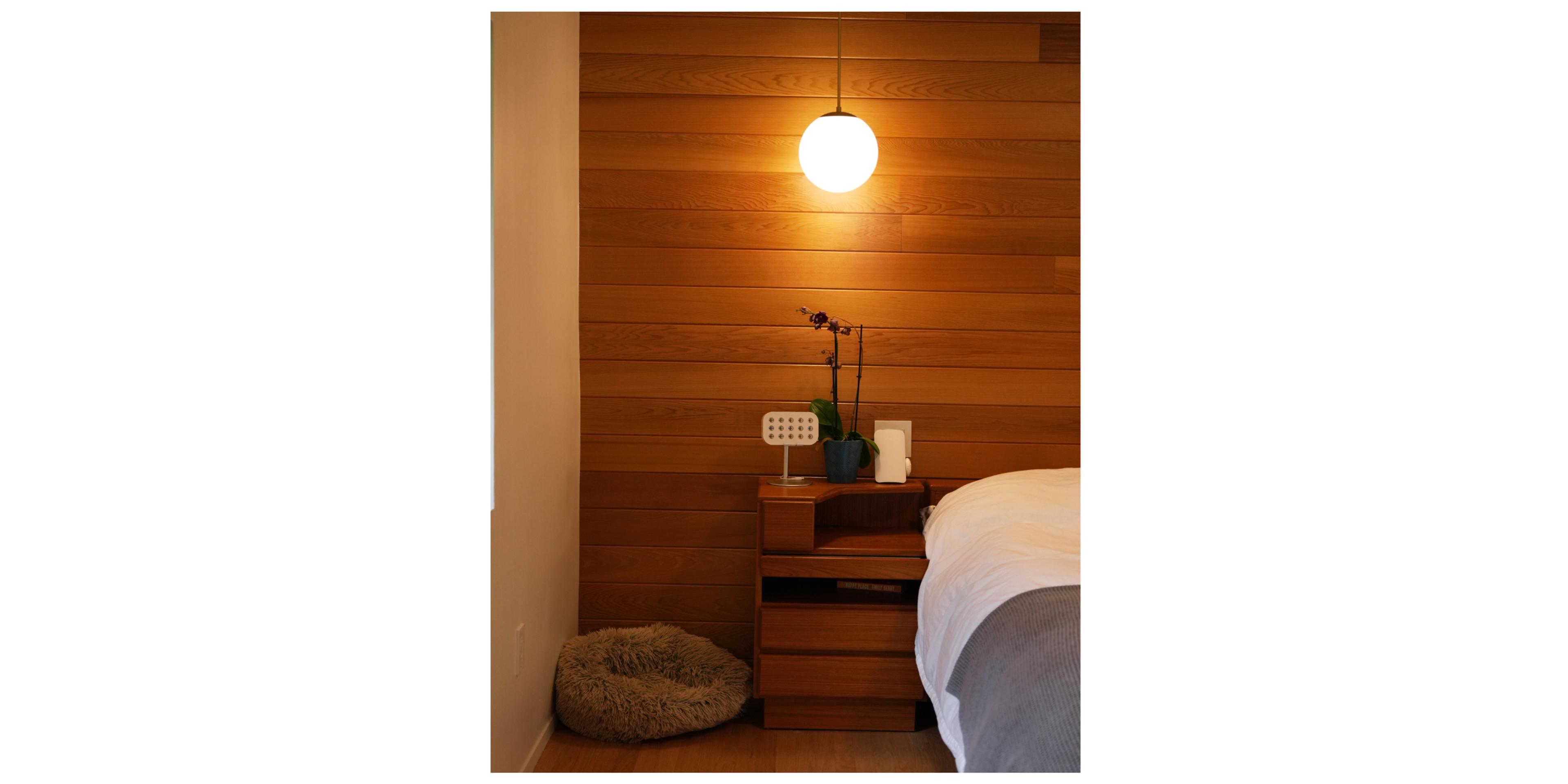 wood paneled bedroom with pendant light on