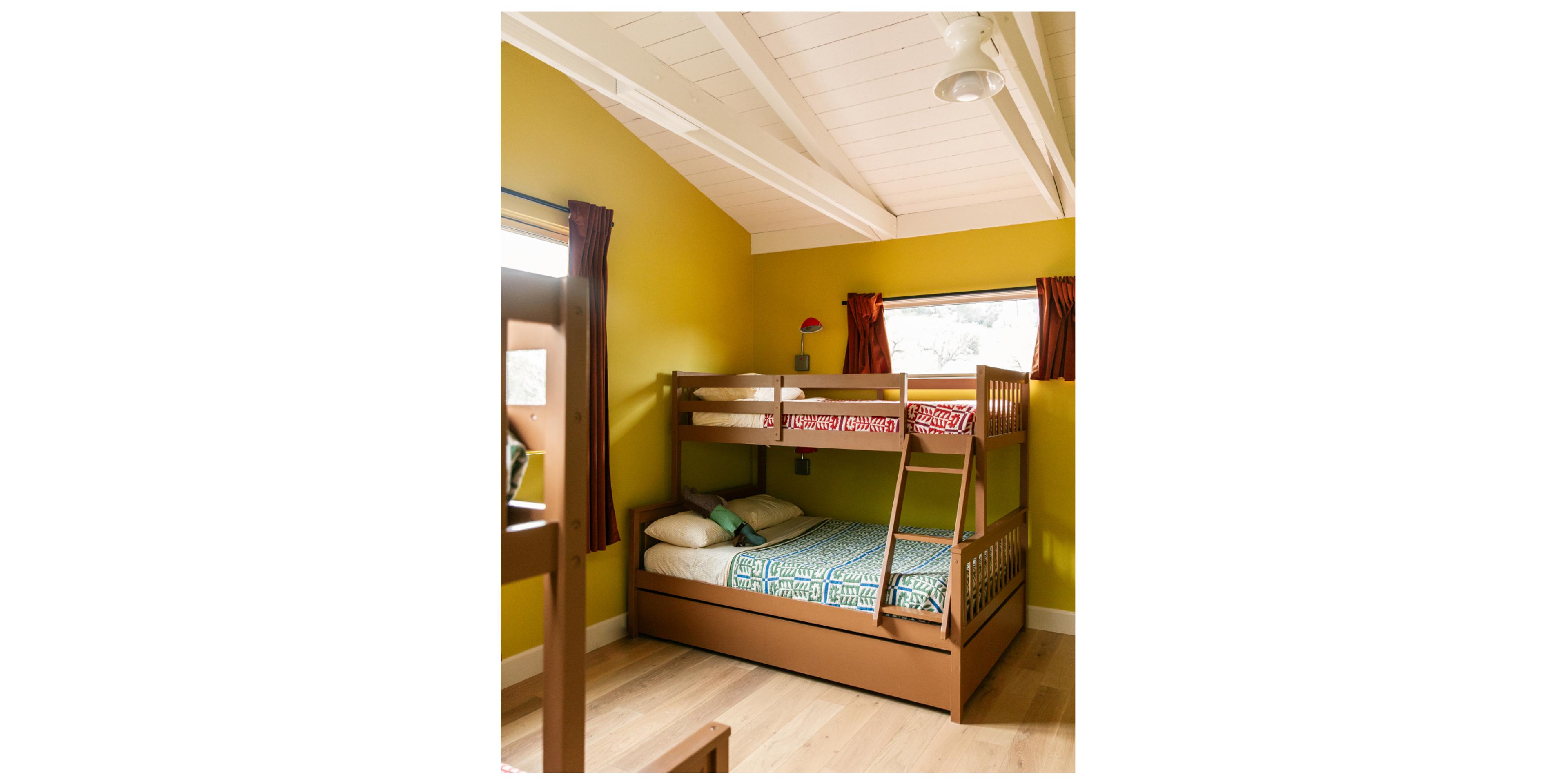 wooden bunkbeds with floral quilts in yellow room