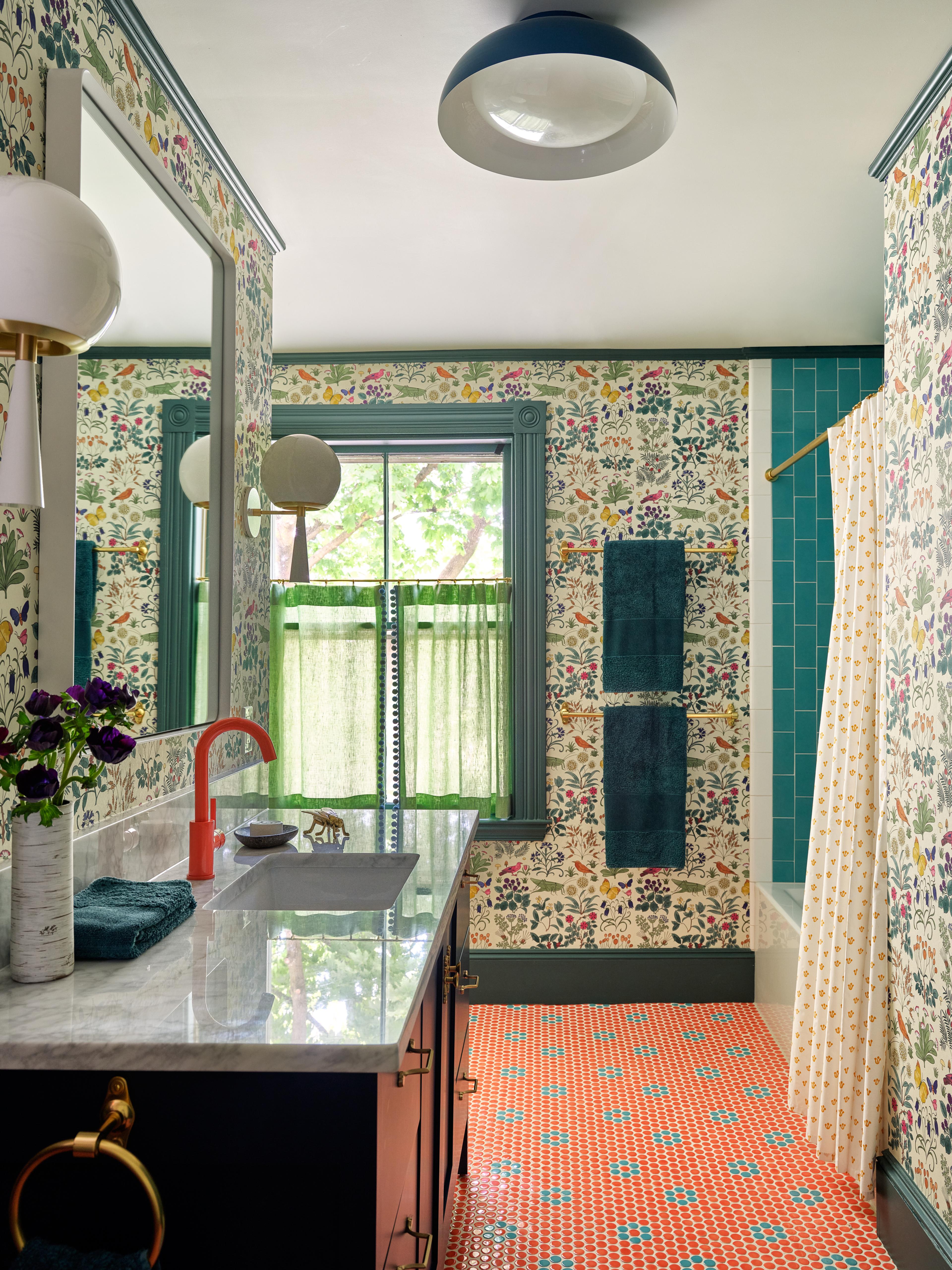 bedroom with blue and white wallpaper, two side tables and two sconce wall fixtures