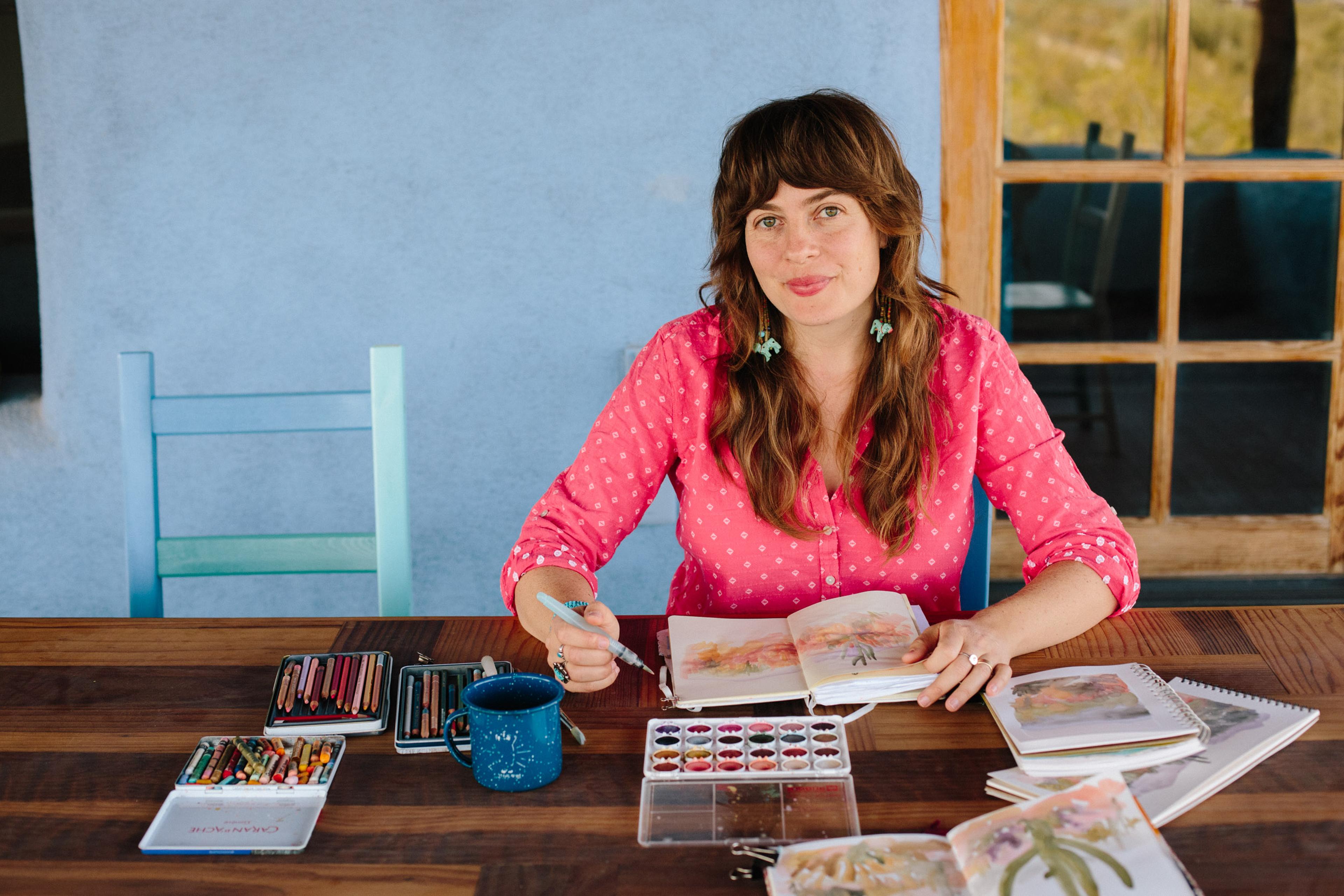 Artist sitting with their painting book and watercolors