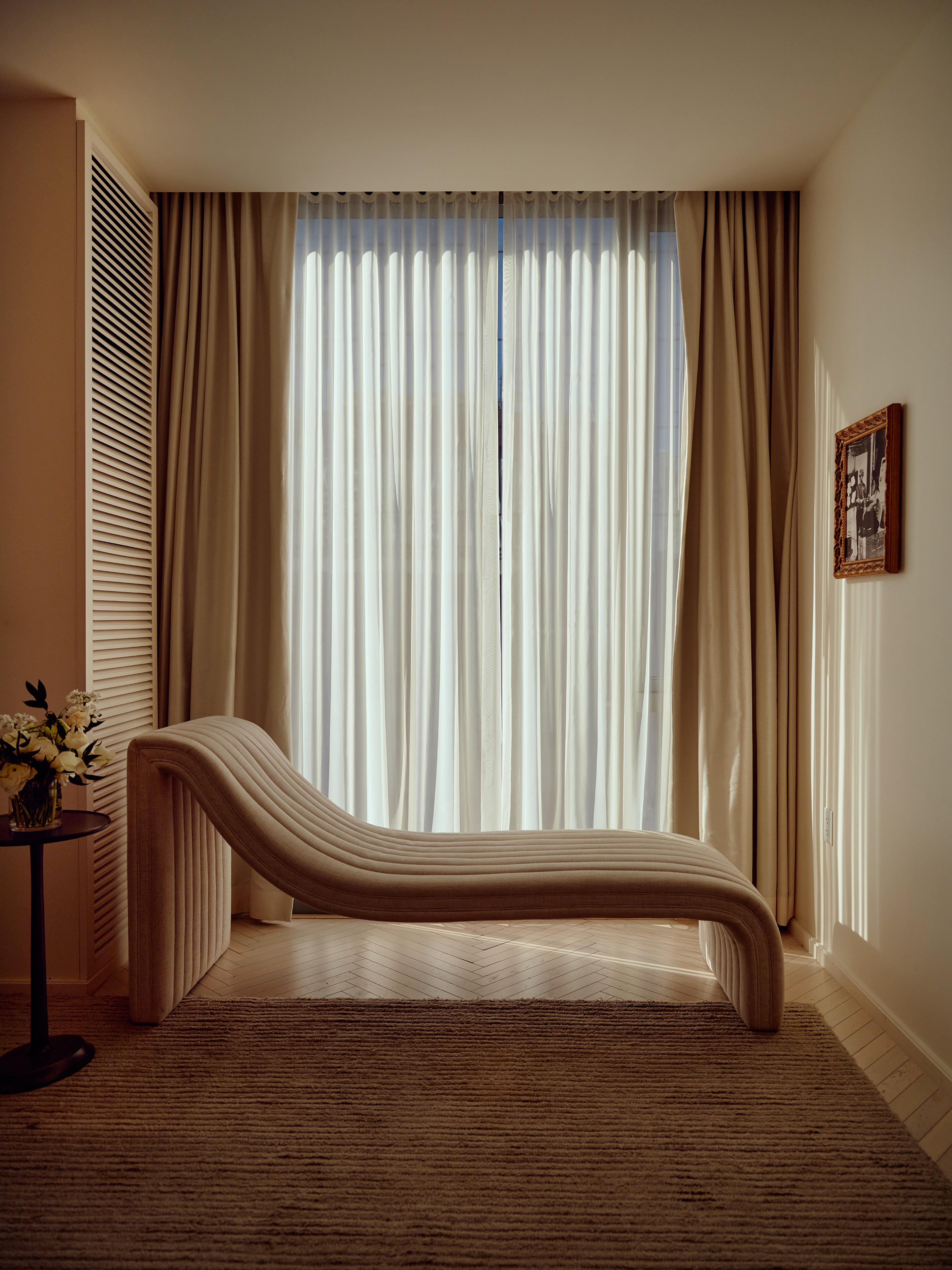 cream day bed in front of white curtains