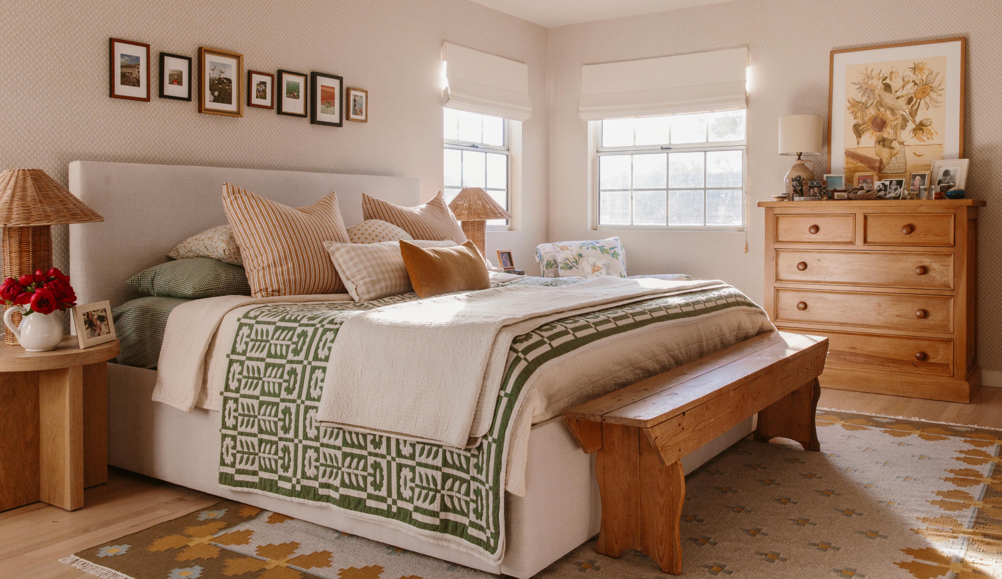 White bedroom with bed in the middle and sun shining through the window
