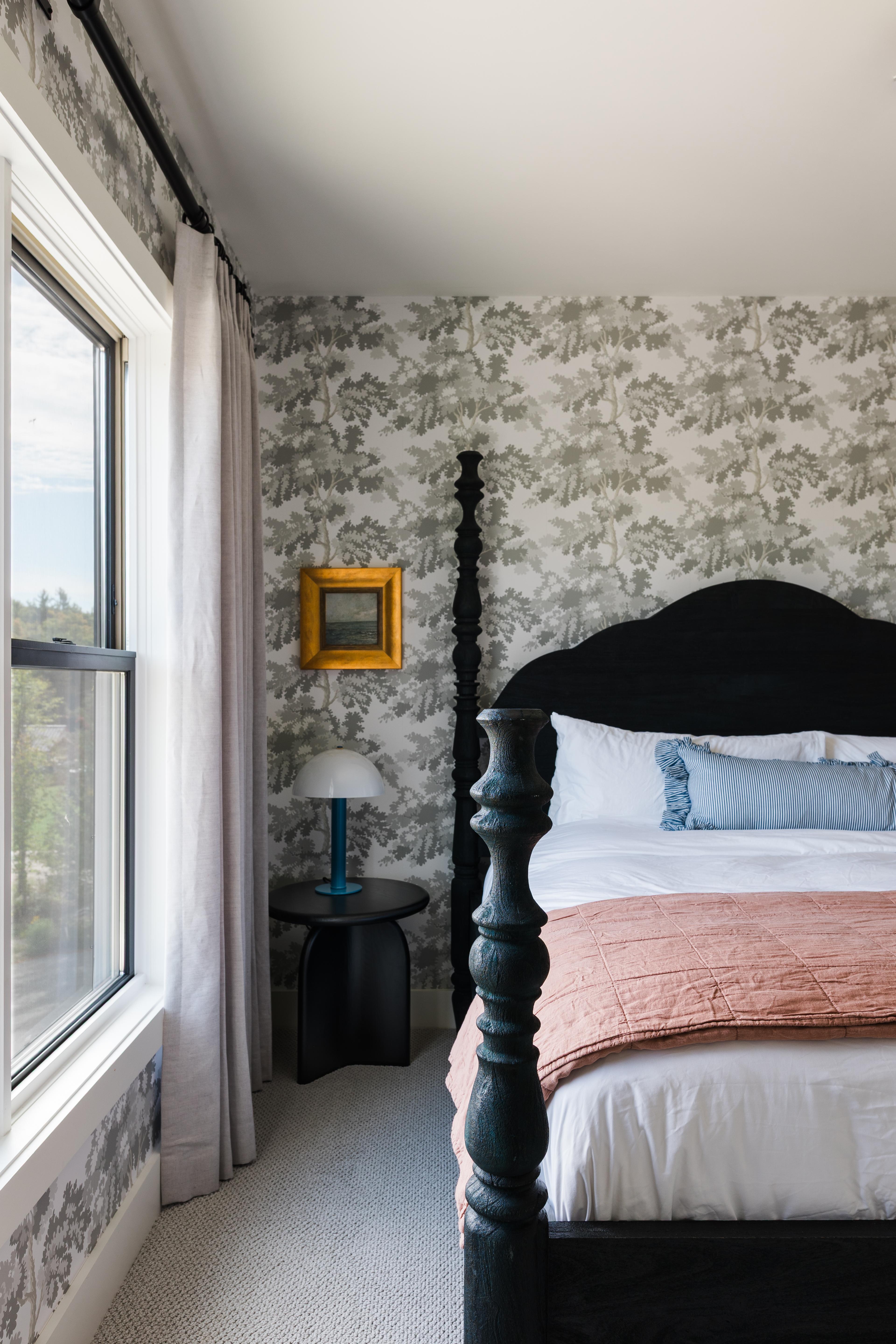Bedroom with black four poster bed and wallpaper