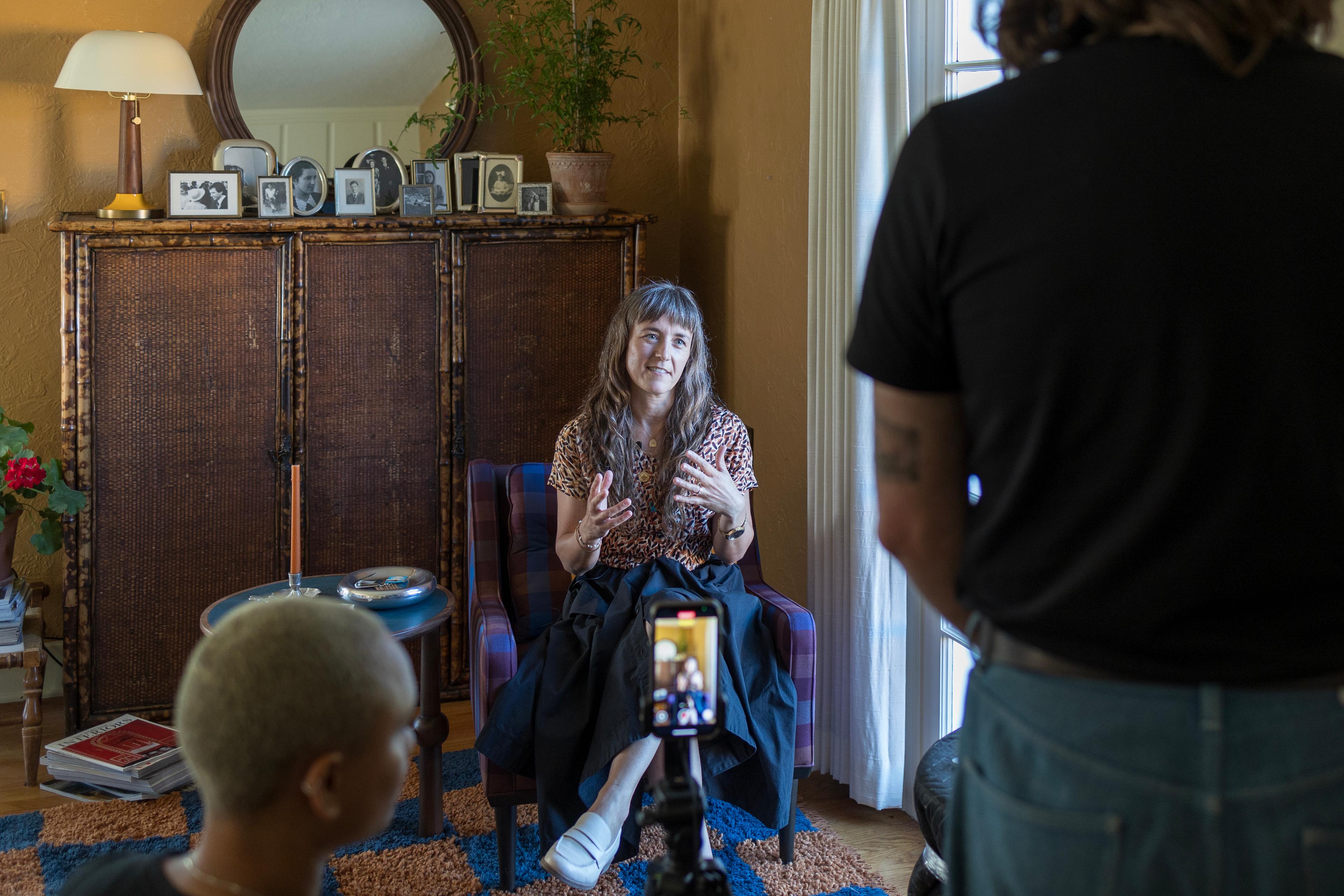 Woman being filmed while talking to camera.