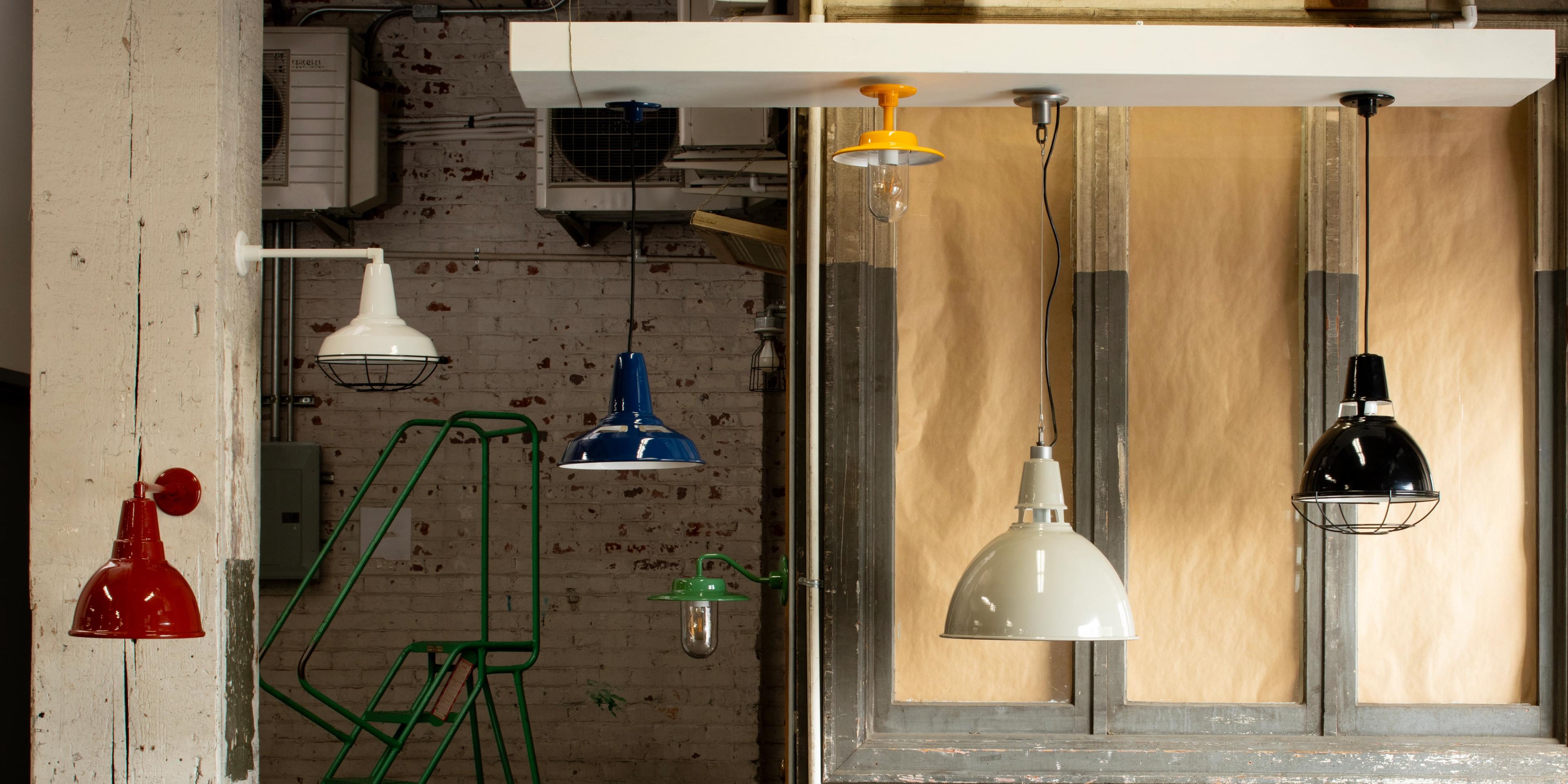 green sconce on white plywood in the middle of factory surrounded by green bell shades