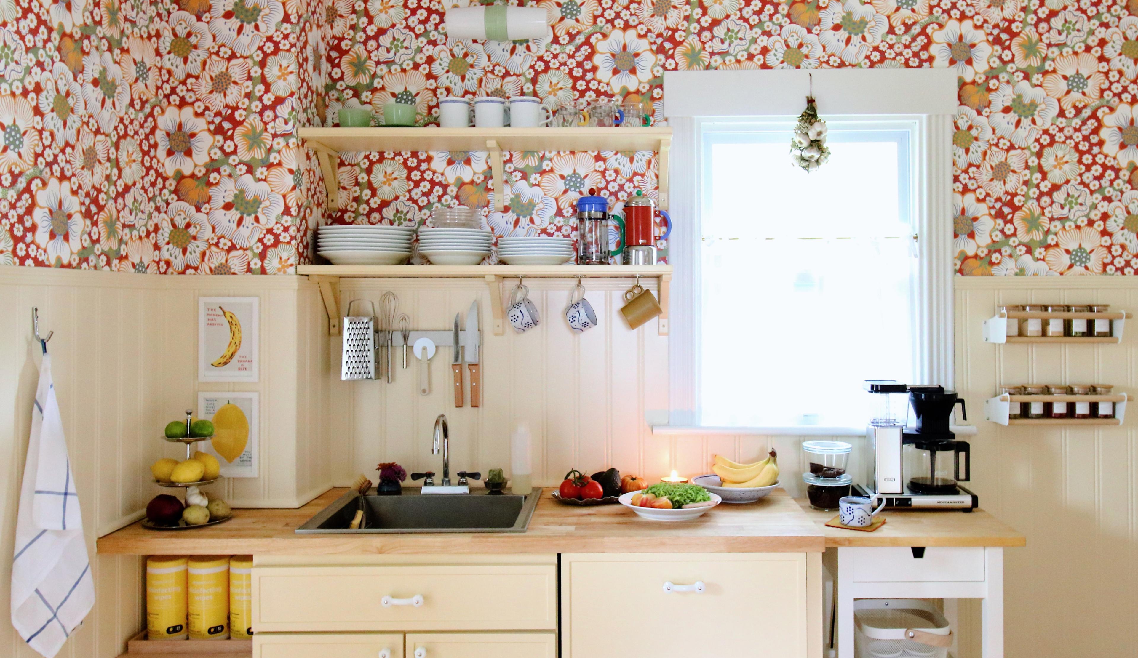 Yellow cottage kitchen with red floral wallpaper