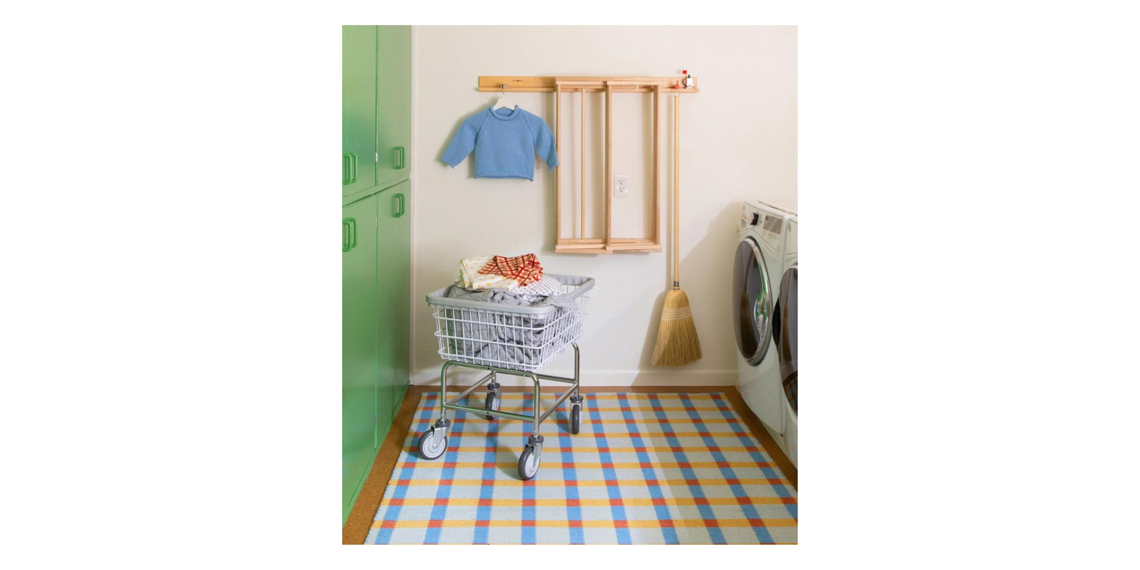 Colorful laundry room with green cabinets.