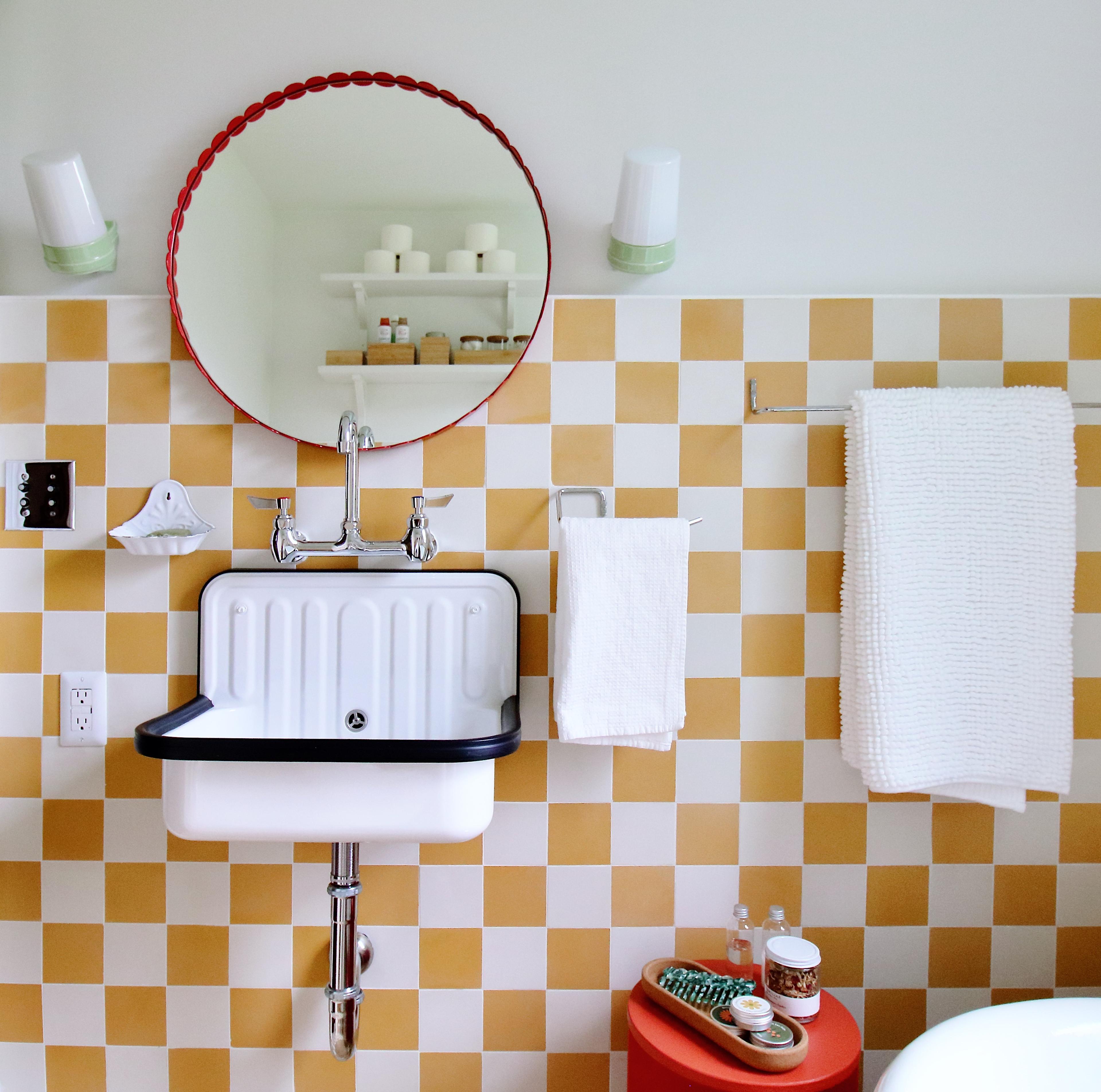 bathroom details with red stool and white sink and red scalloped mirror