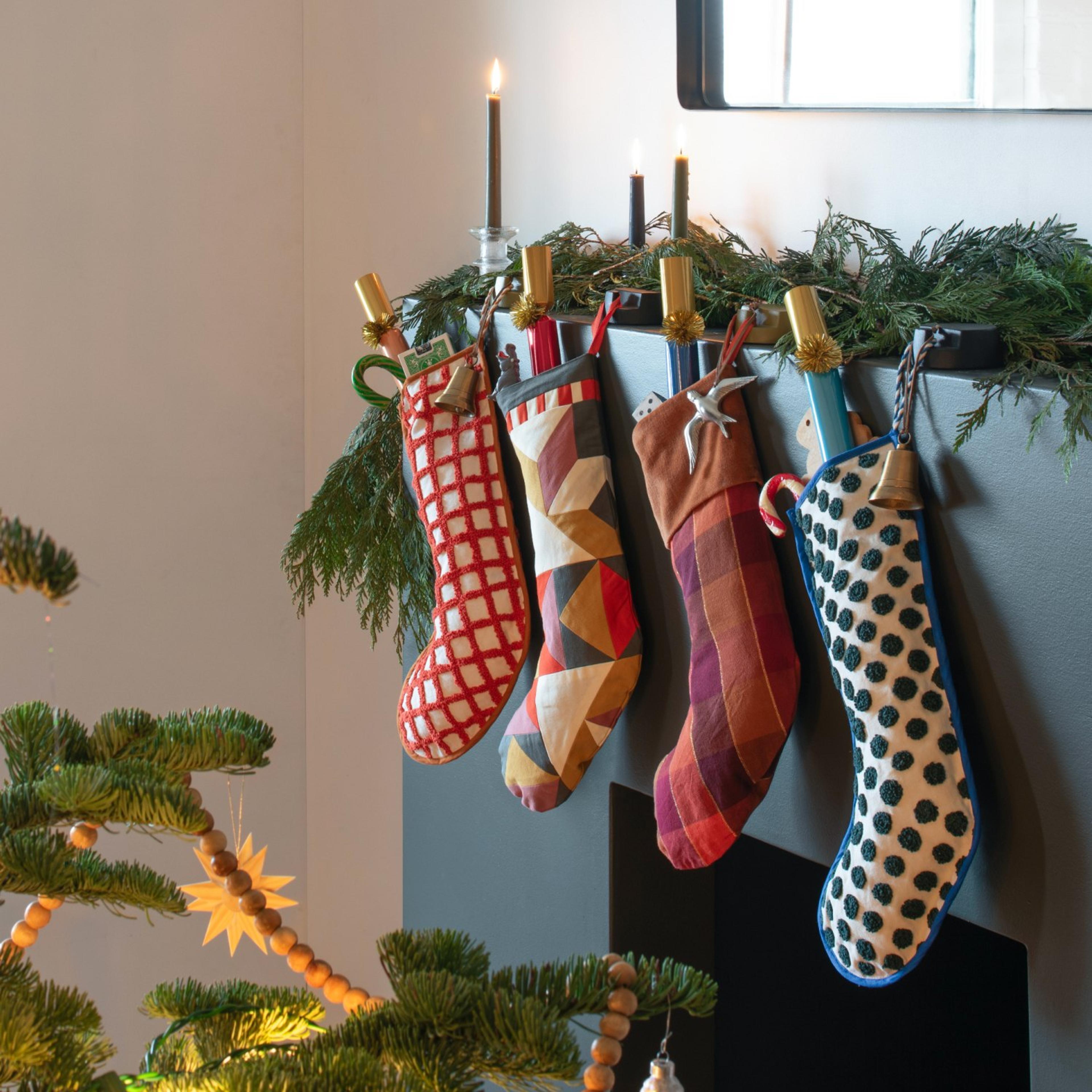 A decorated Christmas tree and a fireplace with stockings.