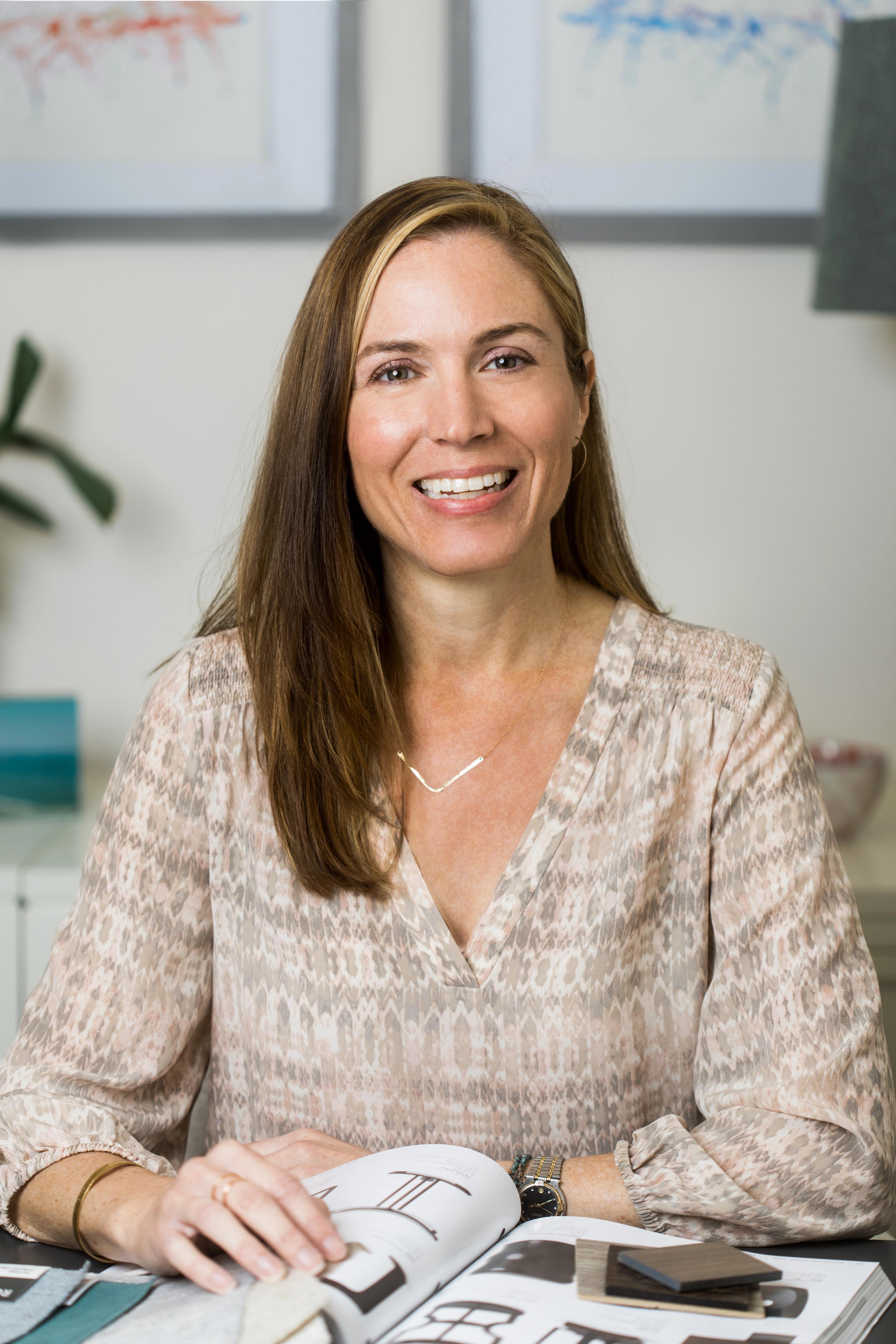 Headshot of woman sitting at desk.