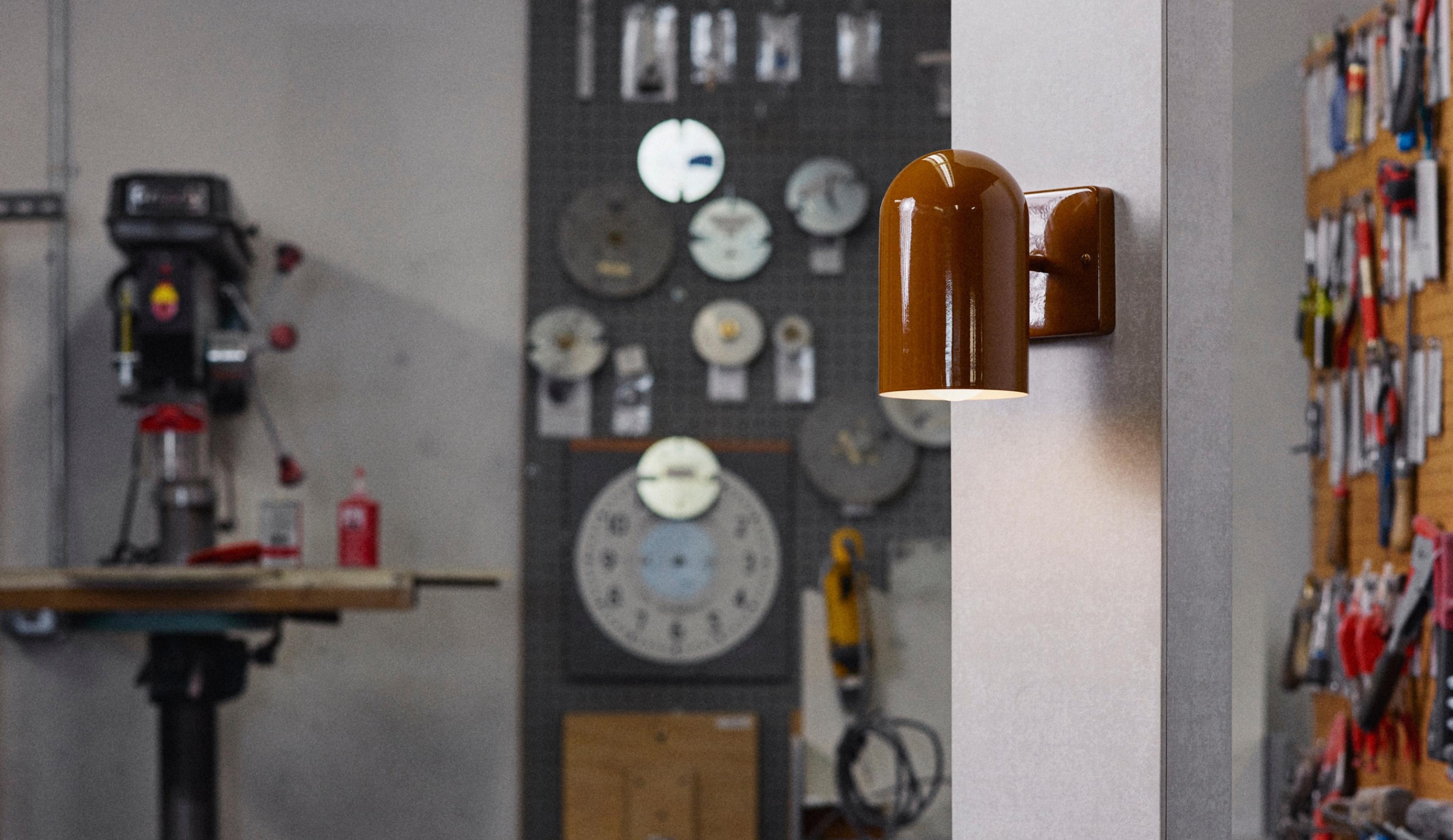 Butterscotch sconce on white wood in factory setting