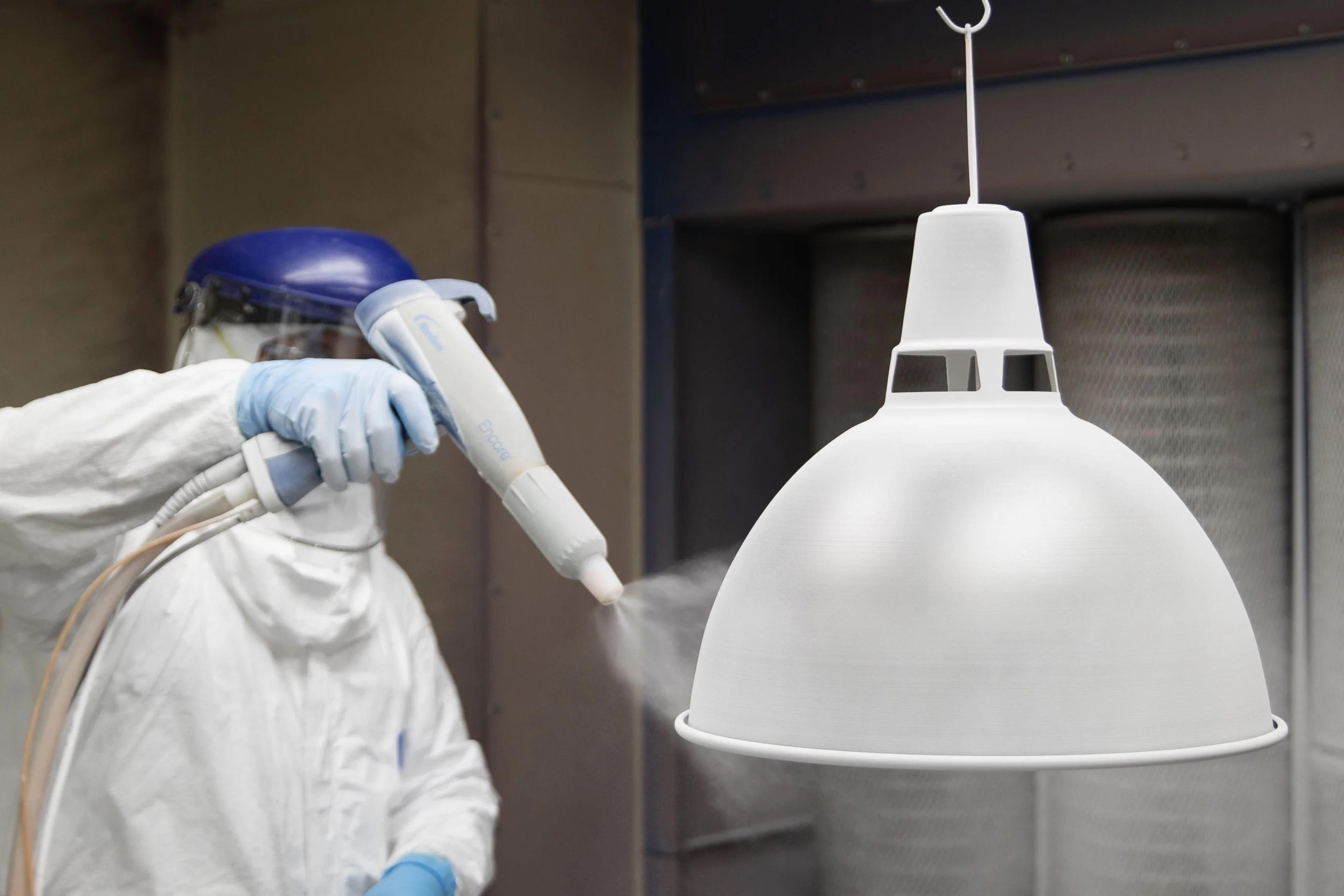 Factory worker paining shade with white paint