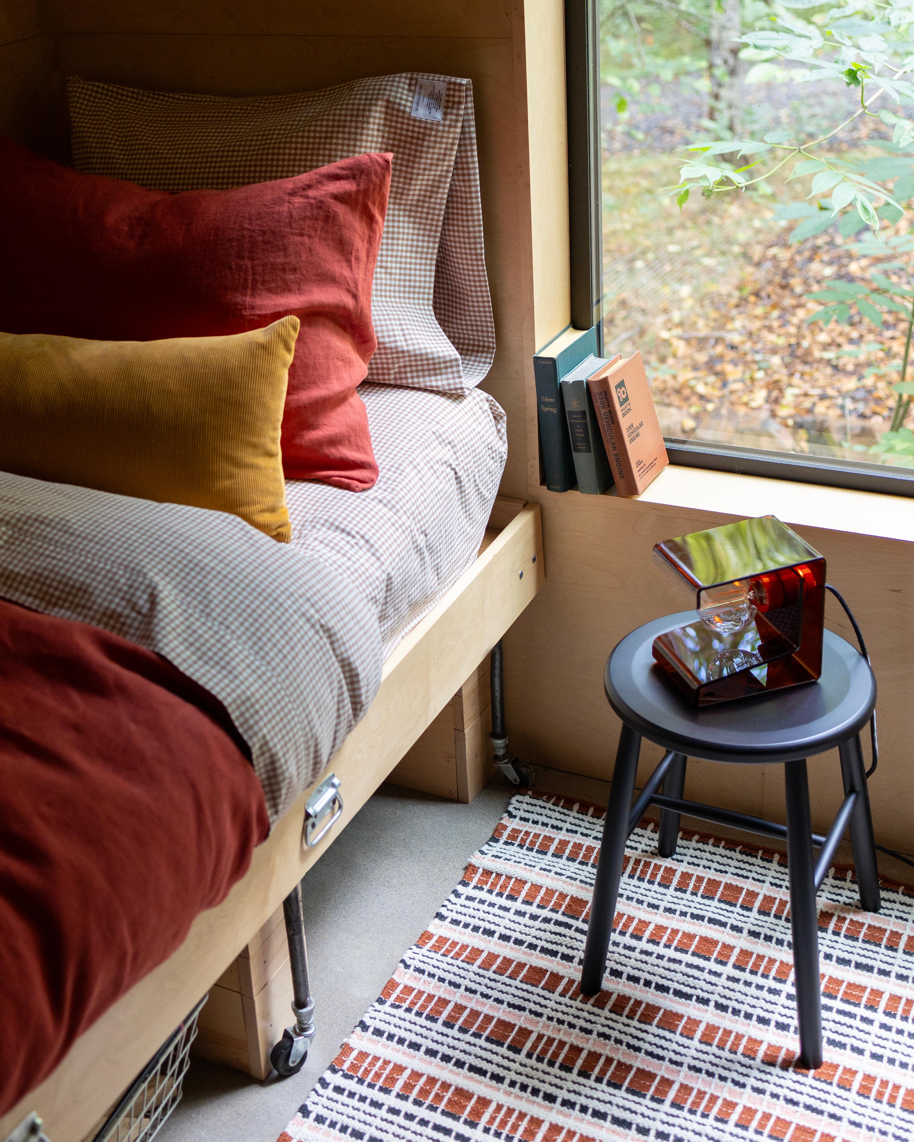 Bedroom with raisin colored duvet cover and side table with lamp