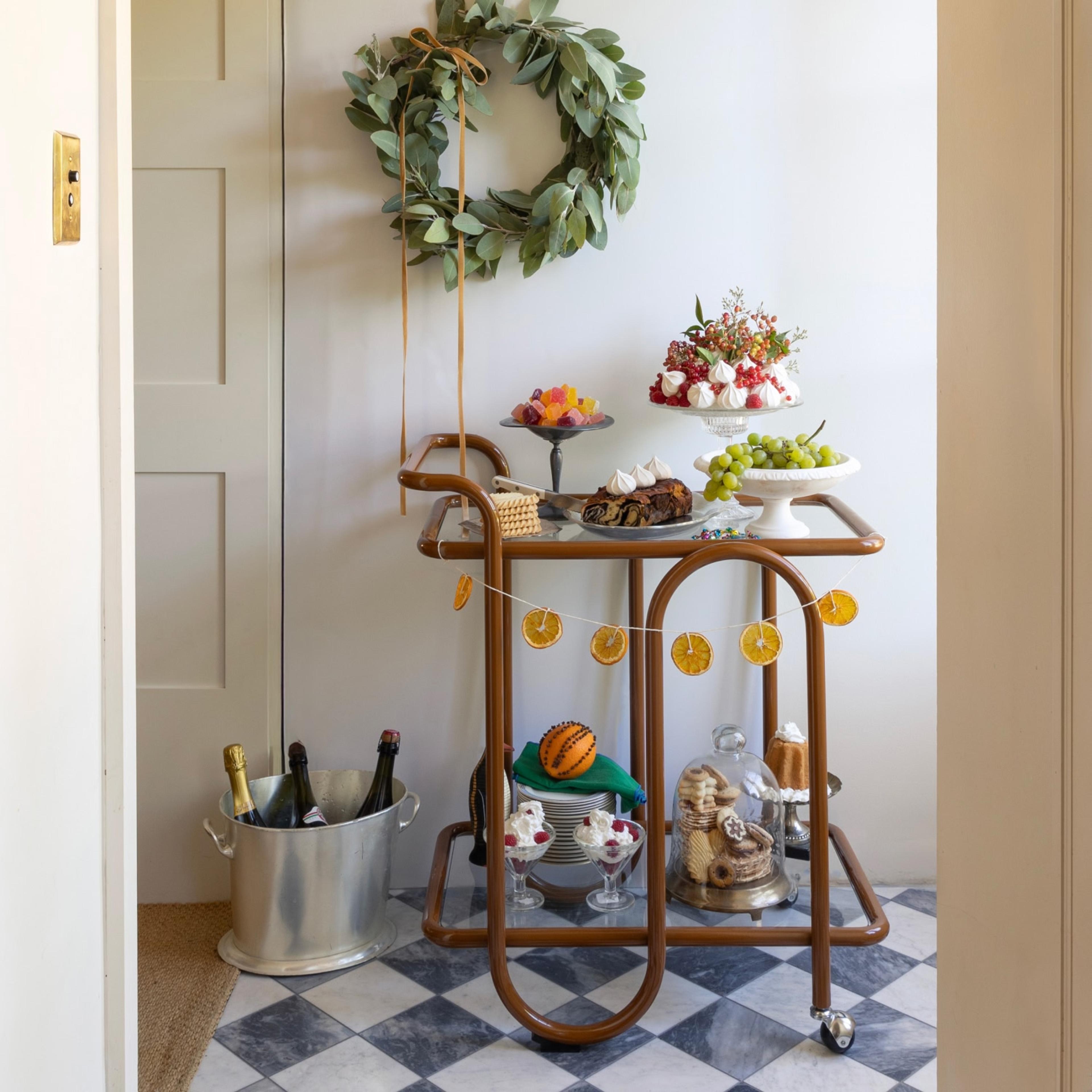 Holiday decorated bar cart in white hallway