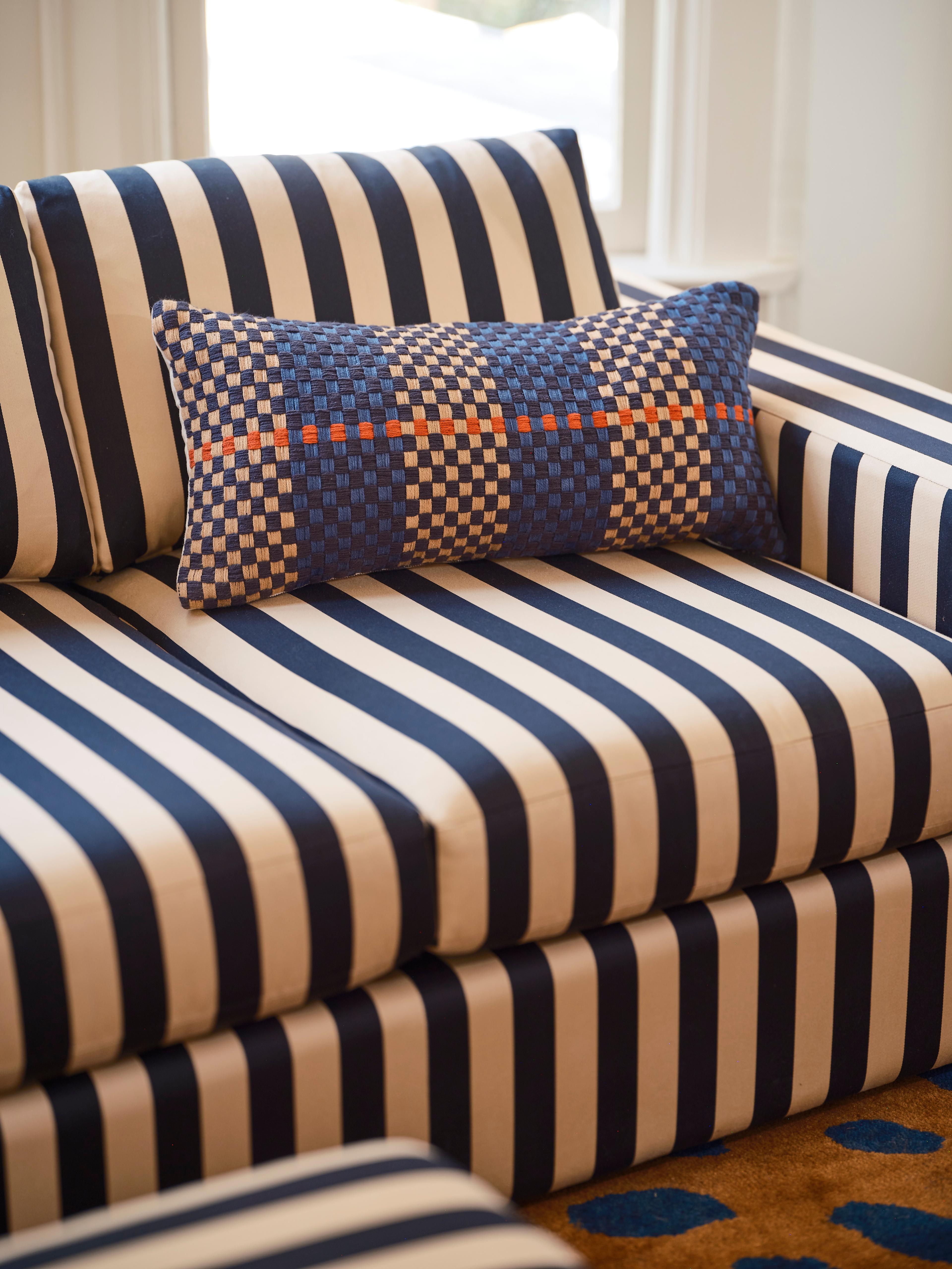 Striped sofa with a funky pillow.