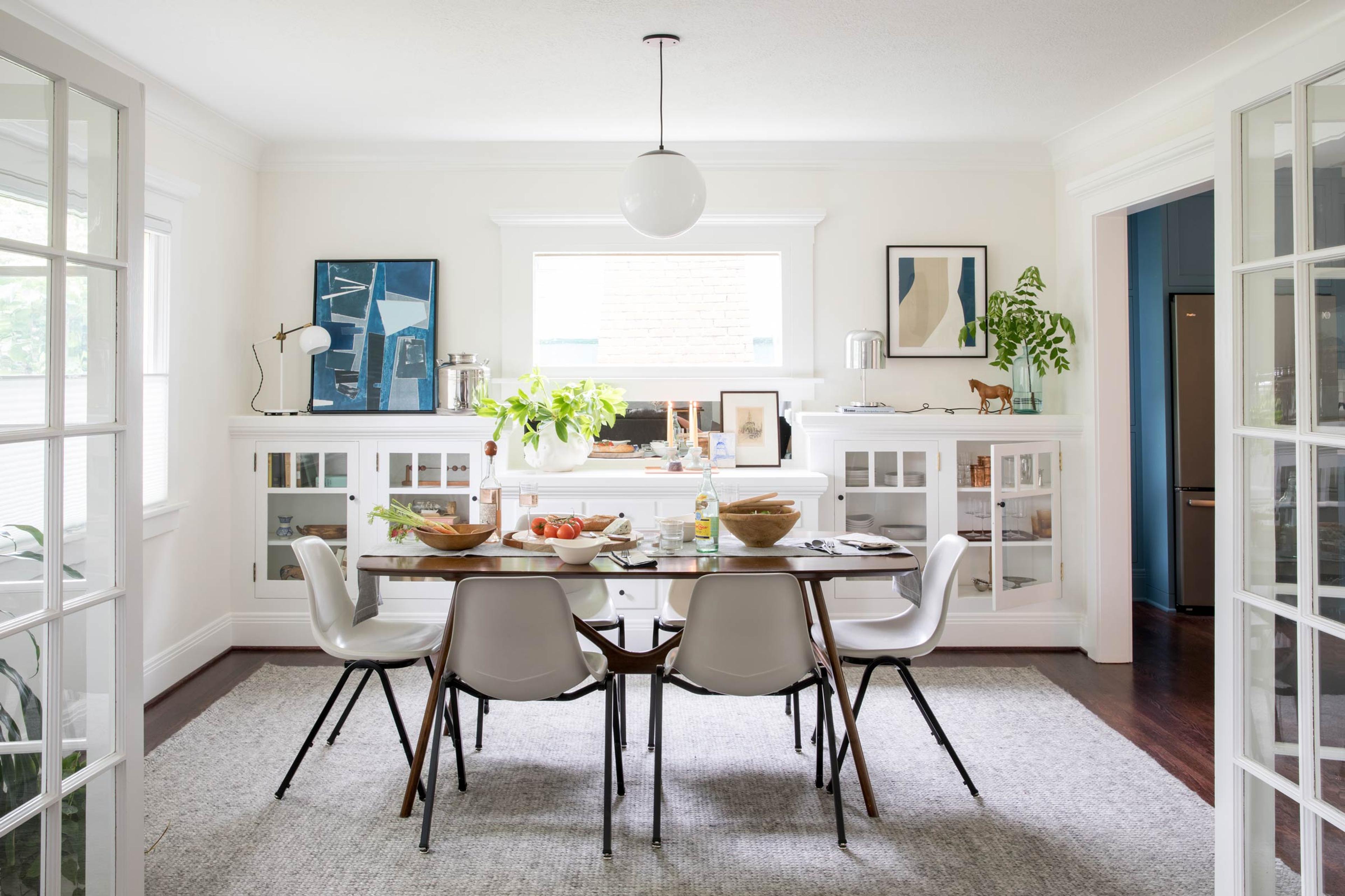 A bright dining room with a globe pendant over the table. 