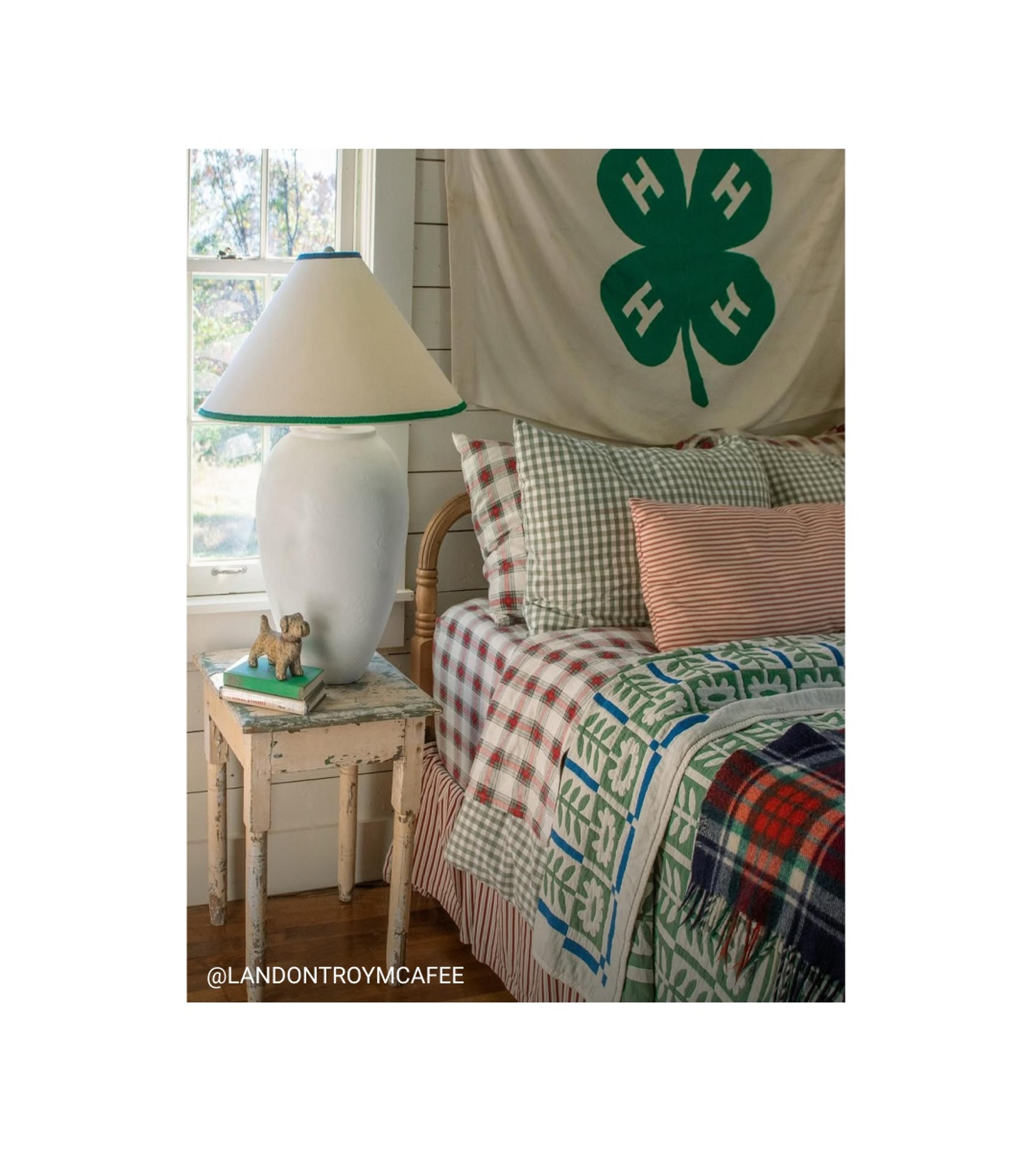 Rustic bedroom with four leaf clover flag behind the bed. 