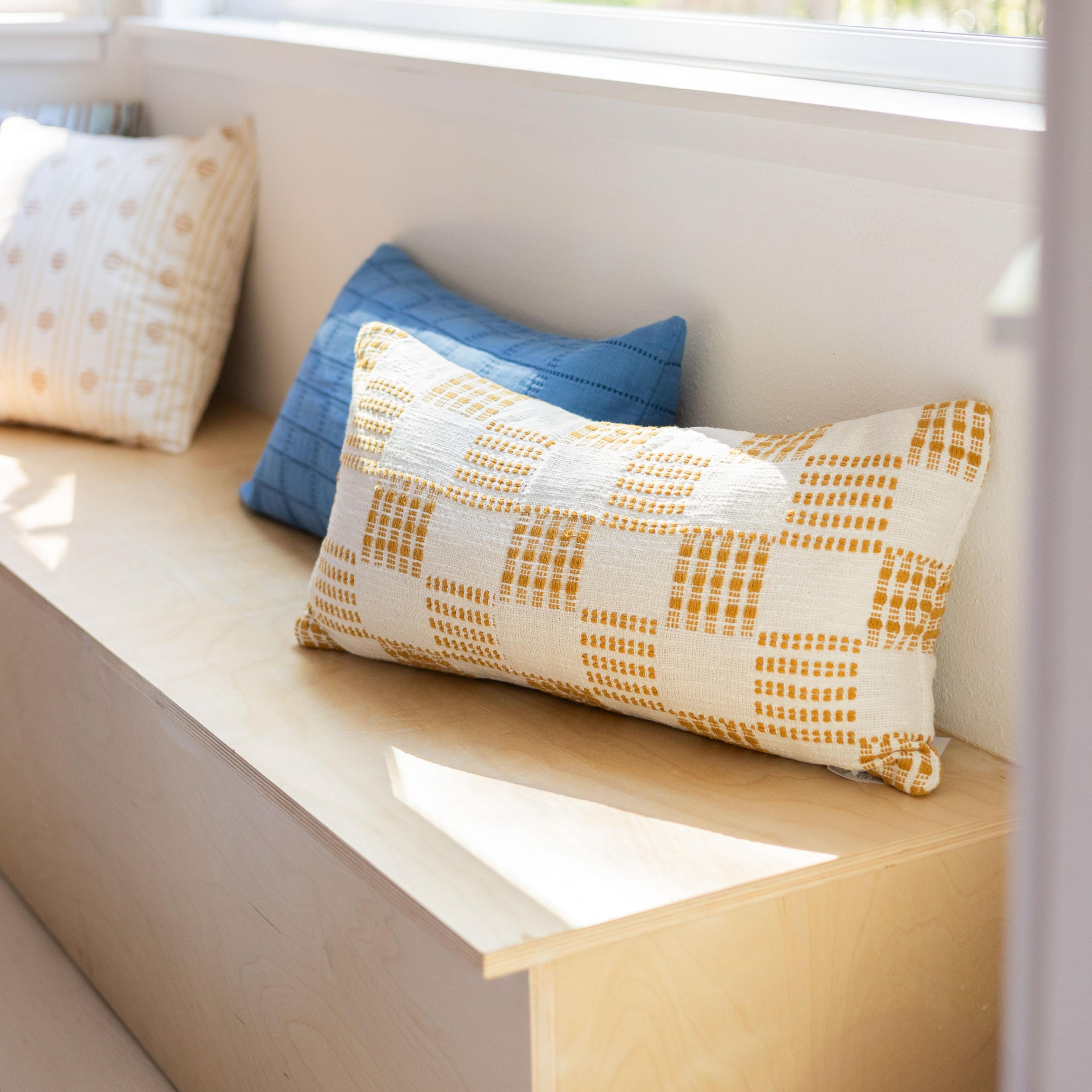 Yellow polka dot pillow on wooden bench