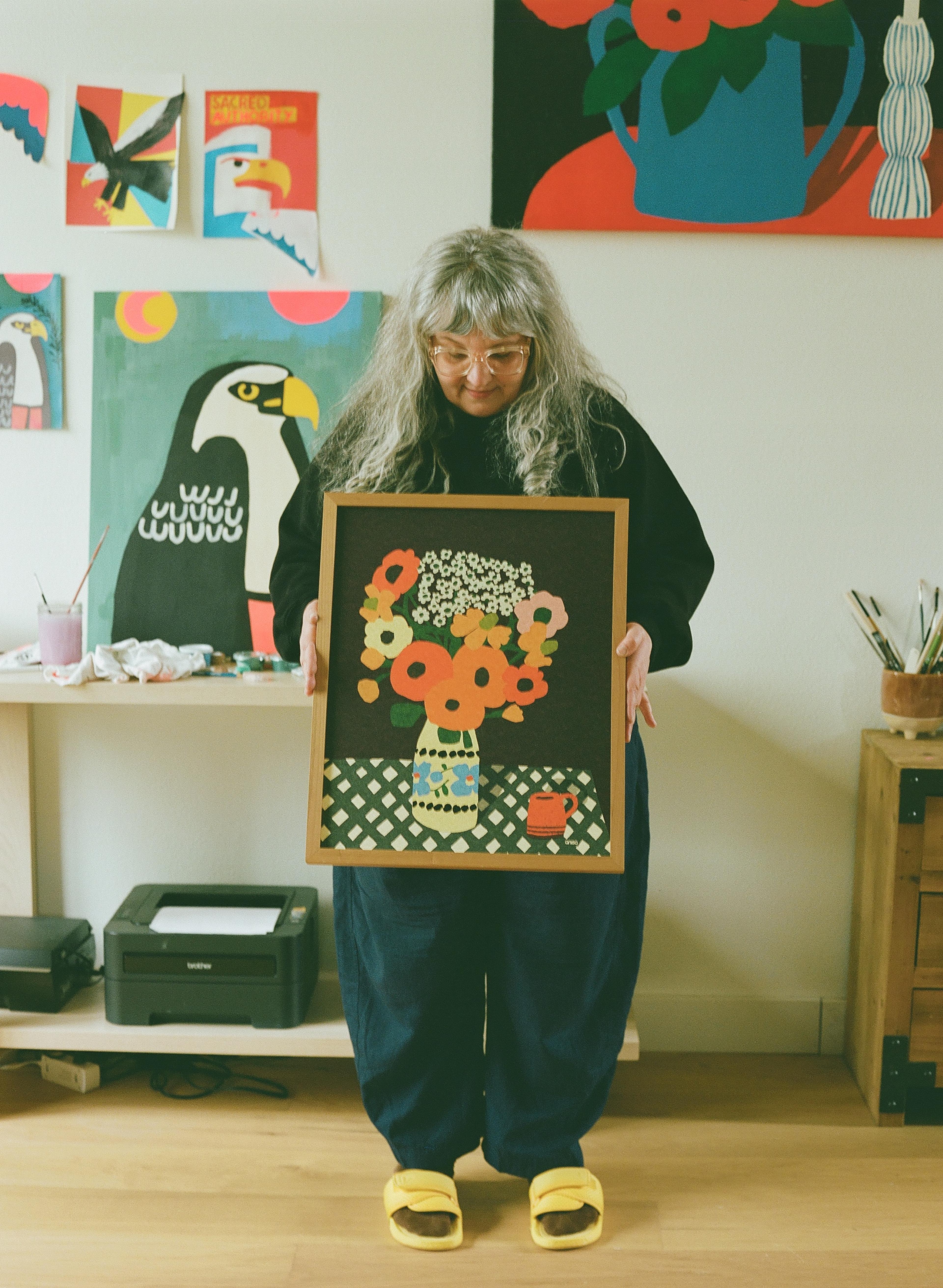 Artist holding print with vase and flowers